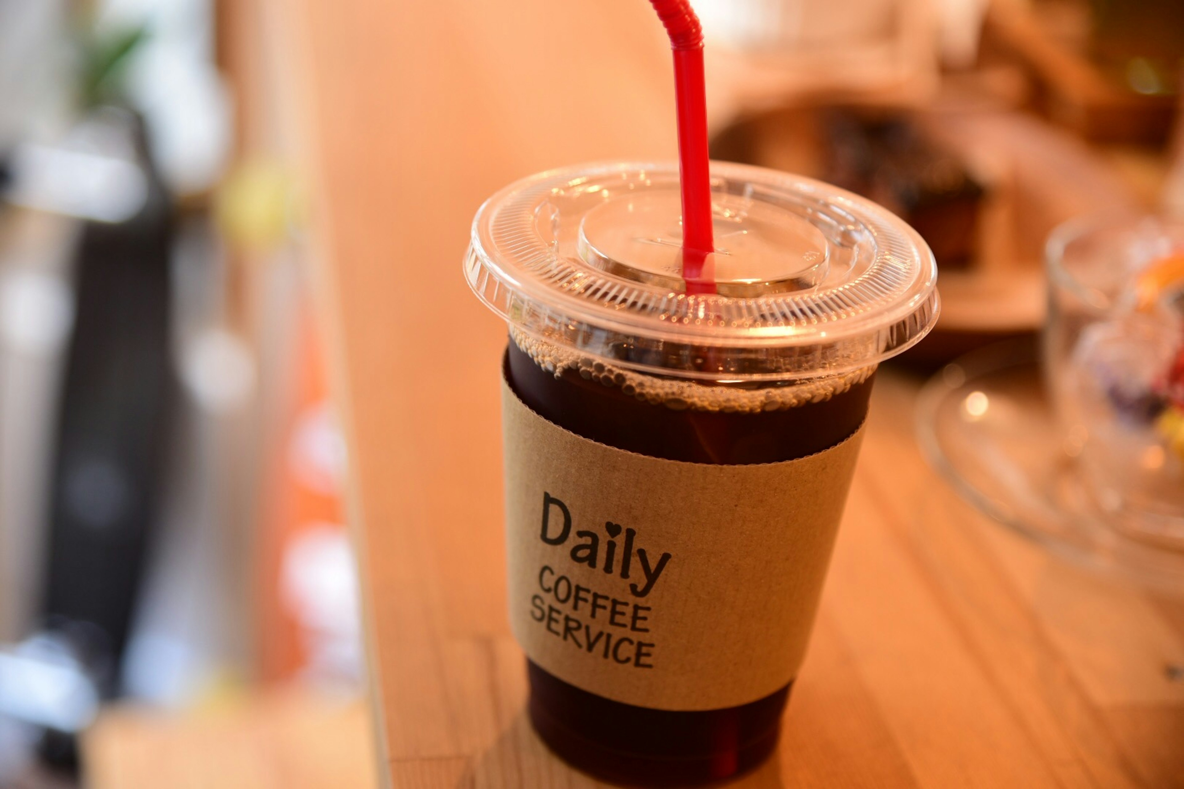 Café helado en un vaso transparente con una pajilla roja