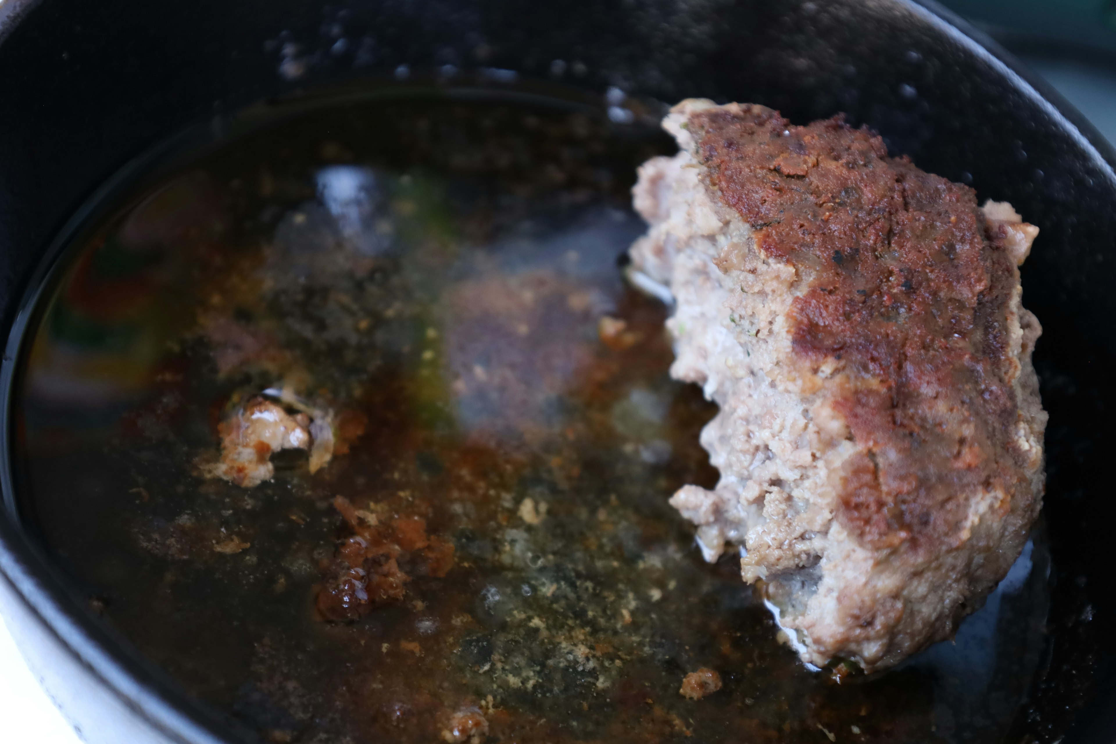 Un morceau de pain de viande dans une casserole avec du bouillon