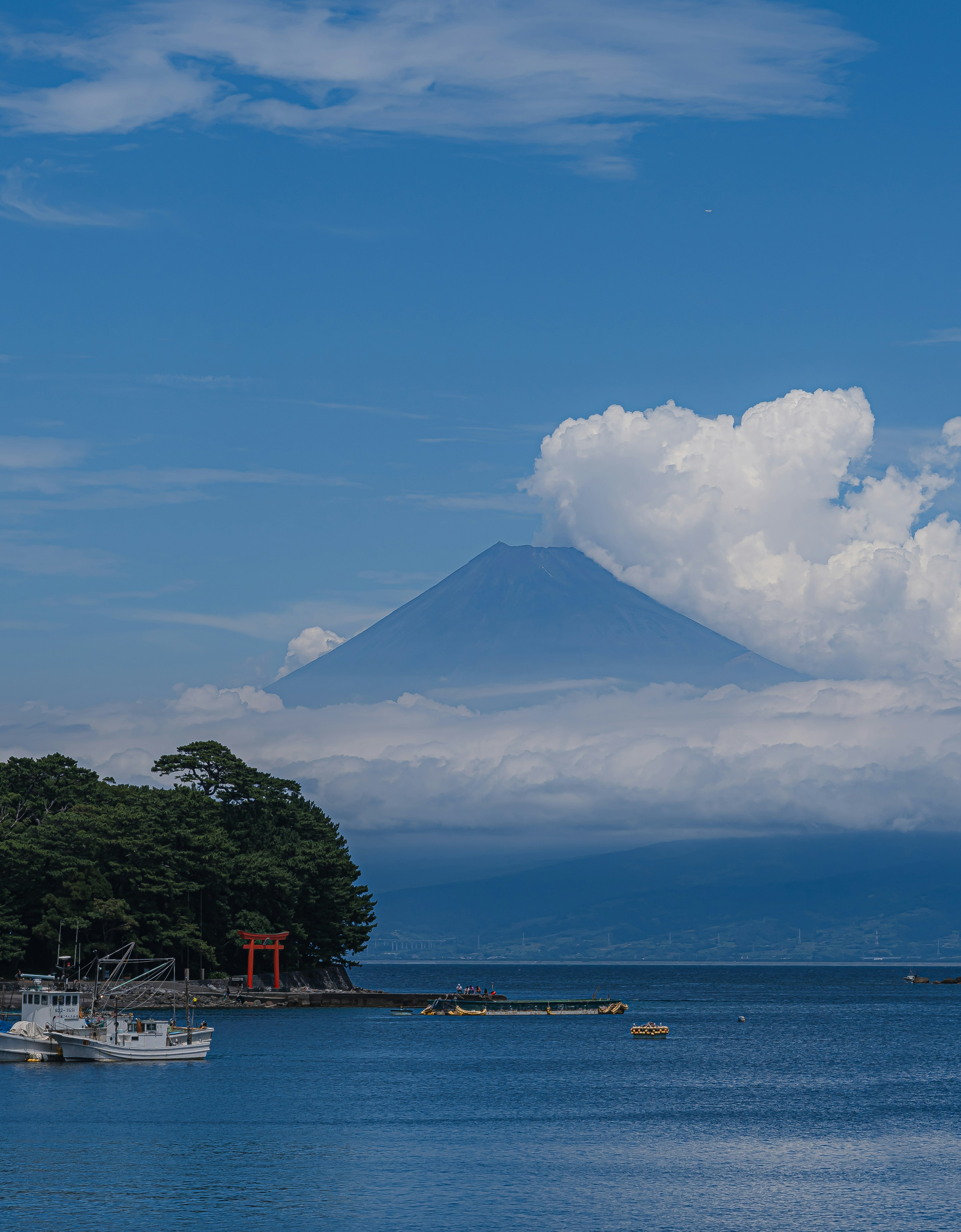 富士山が雲に隠れた美しい風景 海とボートが映える