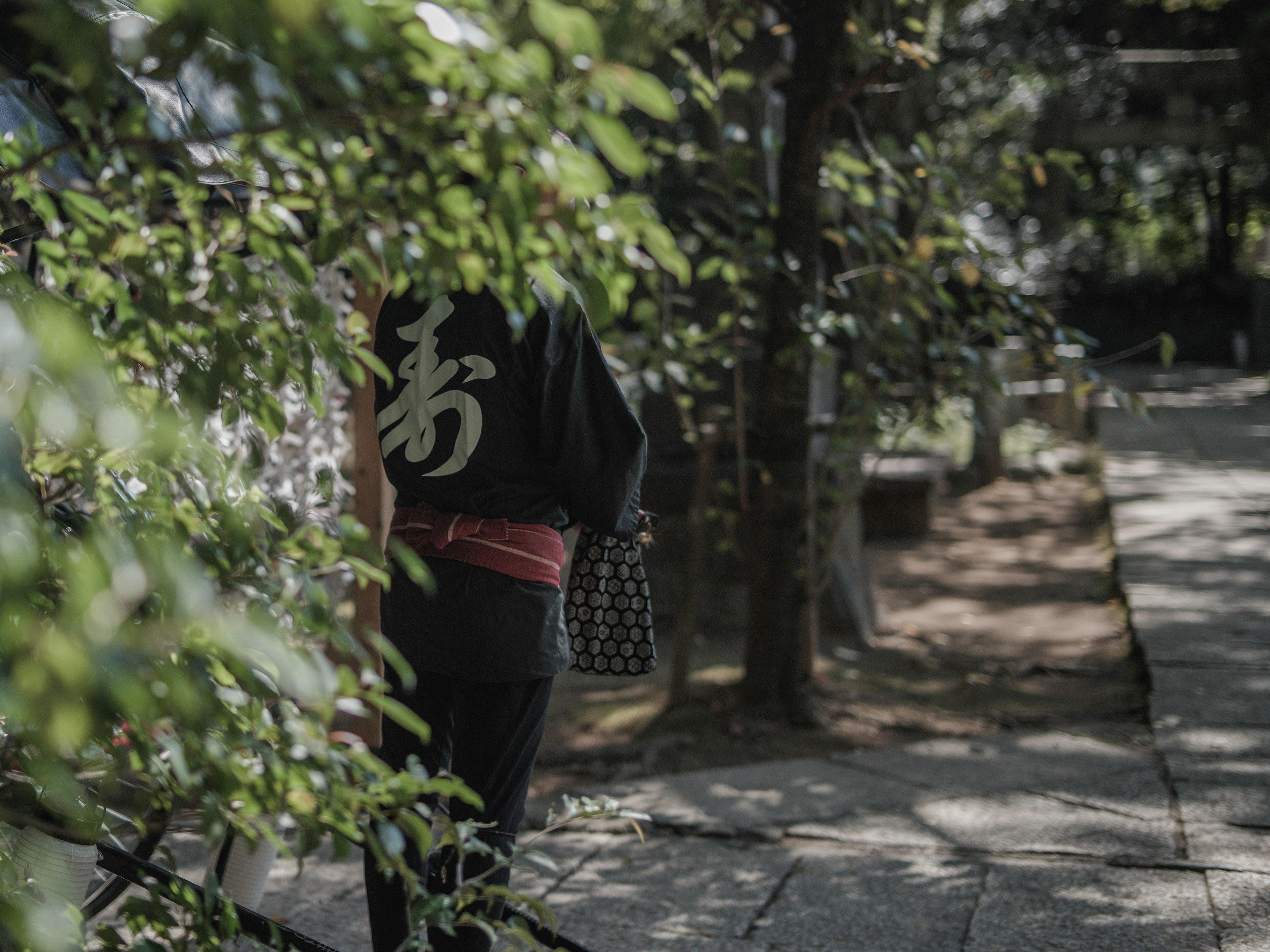 Personne en kimono marchant à travers une verdure luxuriante