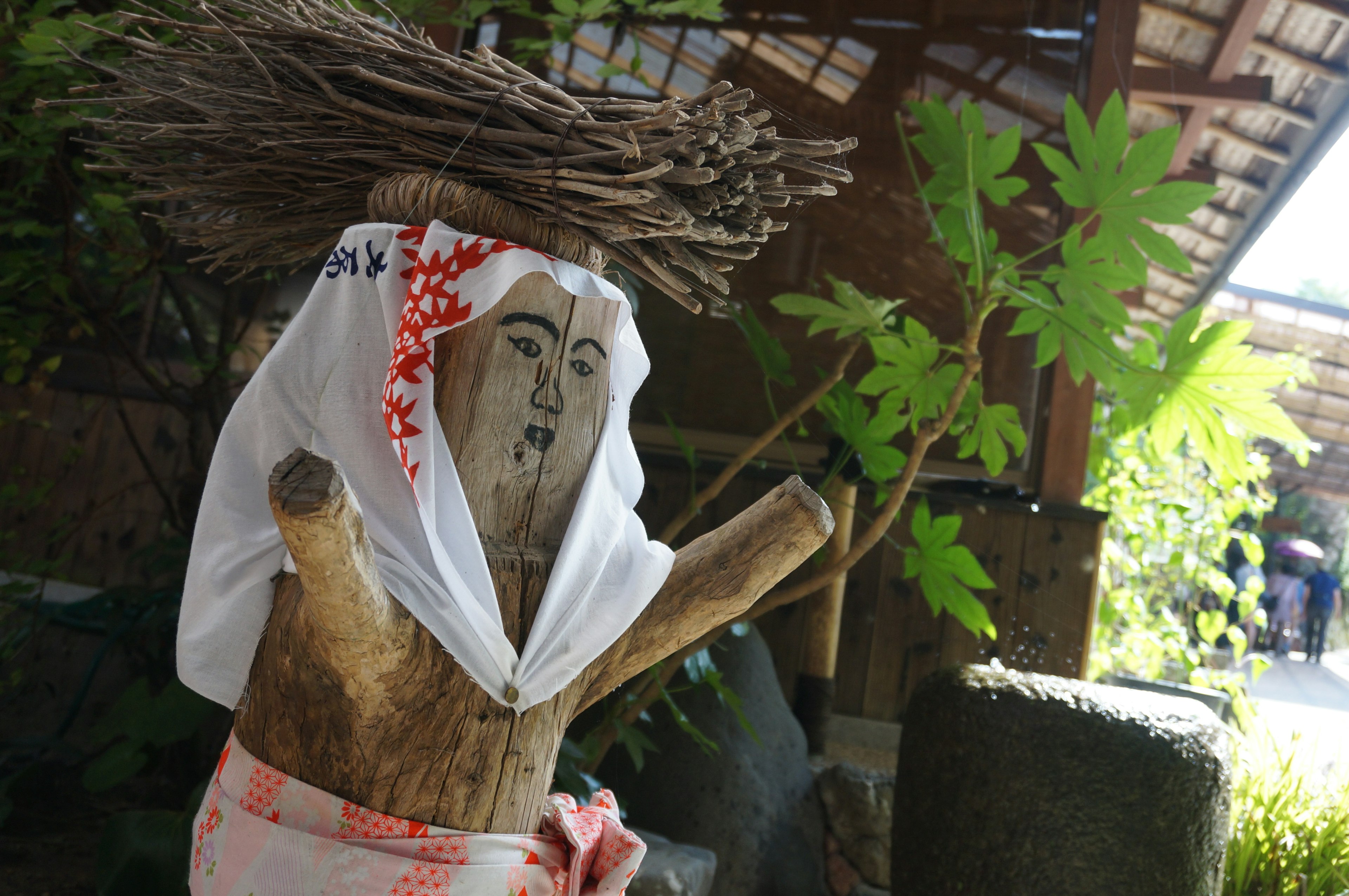 Holzfigur mit einem weißen Stoff und roten Akzenten