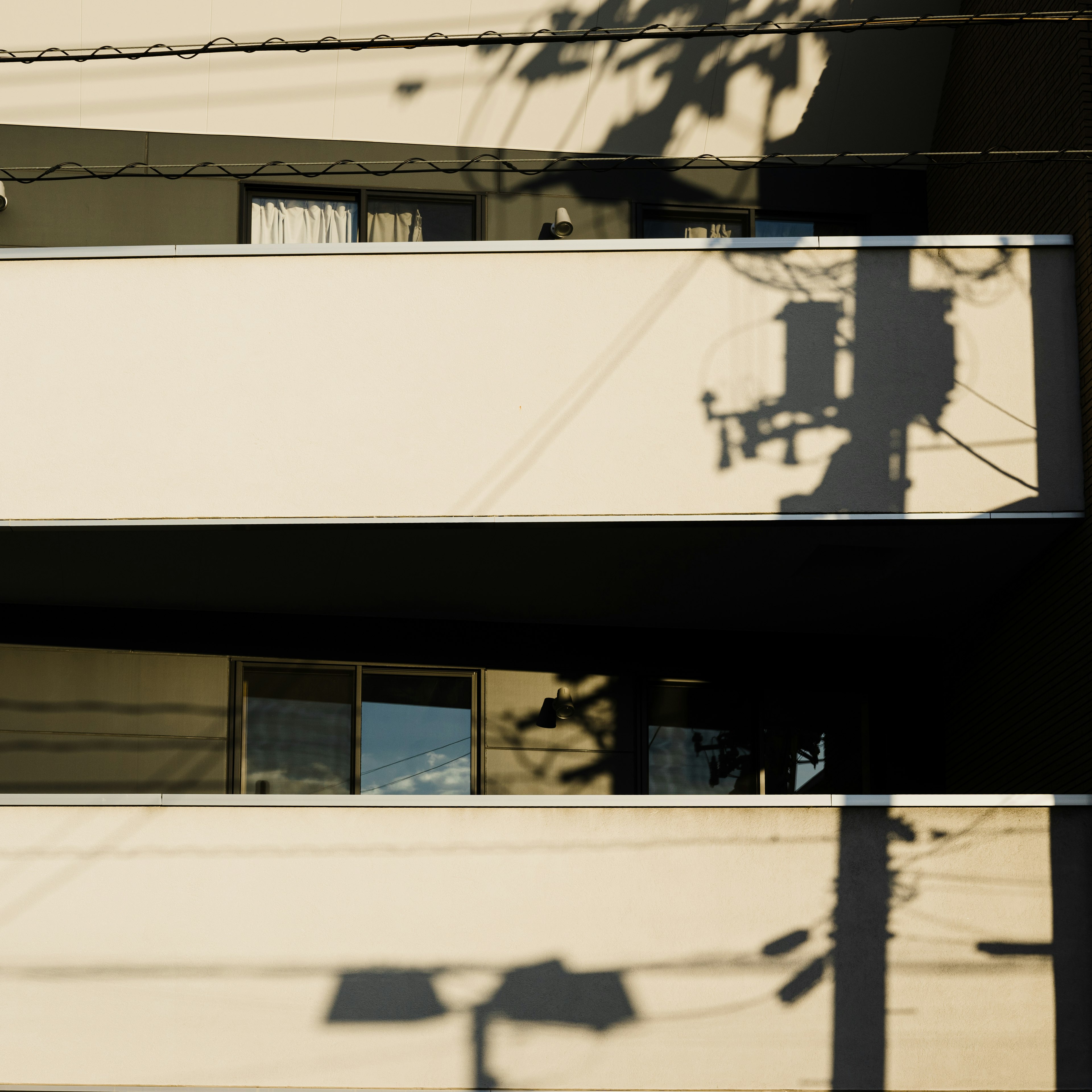 Contraste entre el balcón de un edificio y las sombras creando un efecto artístico