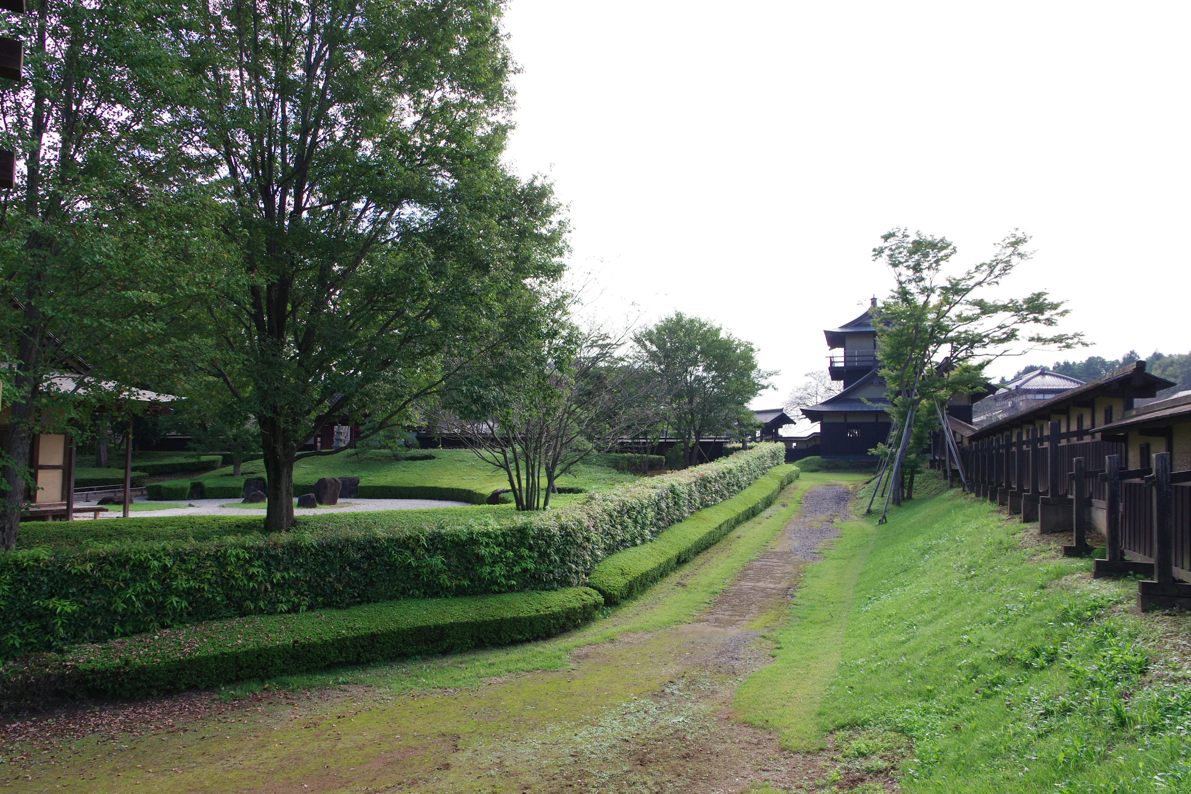 緑豊かな庭園と古い建物がある風景