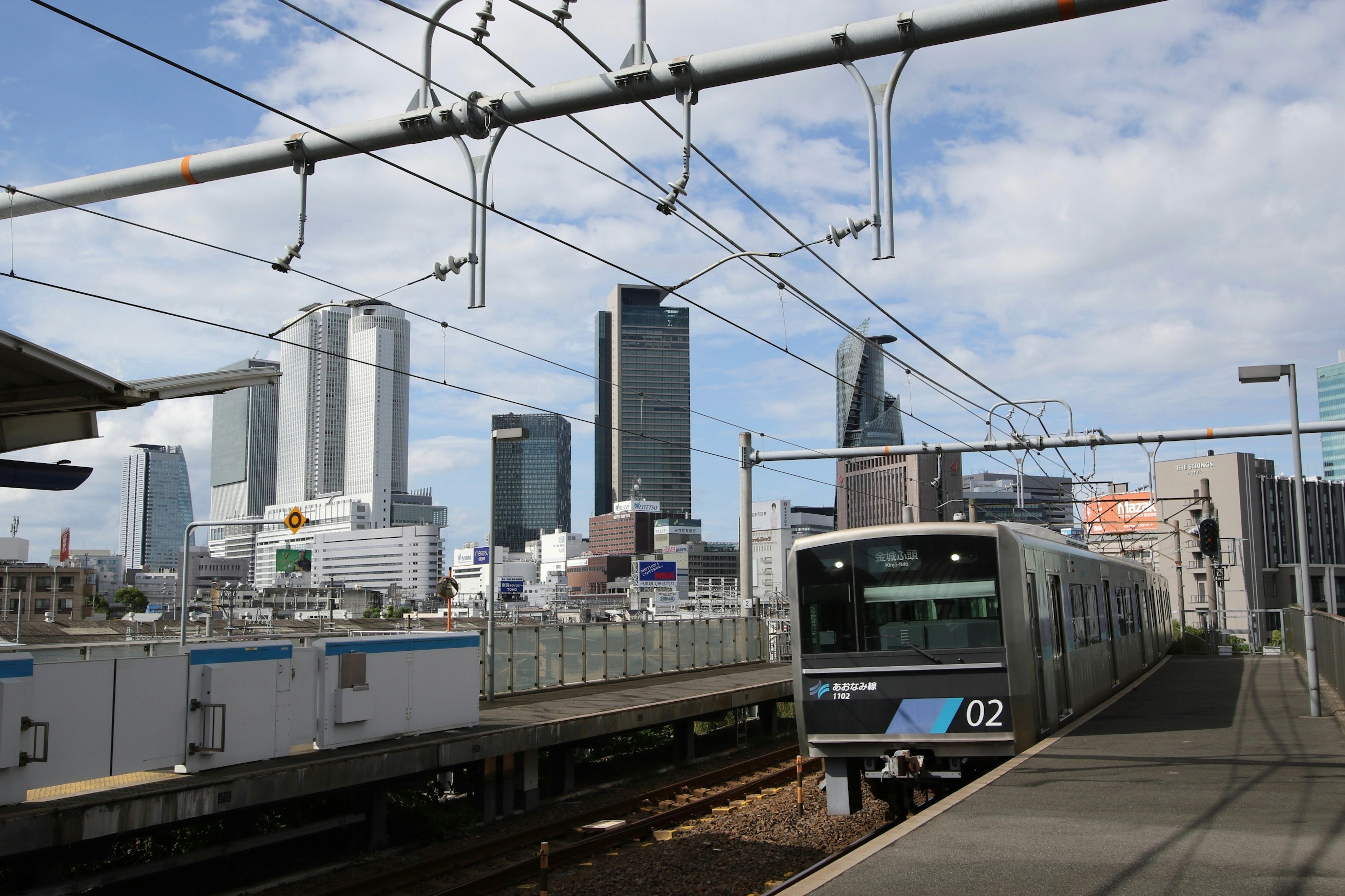 Train stopped at a city station with skyscrapers in the background