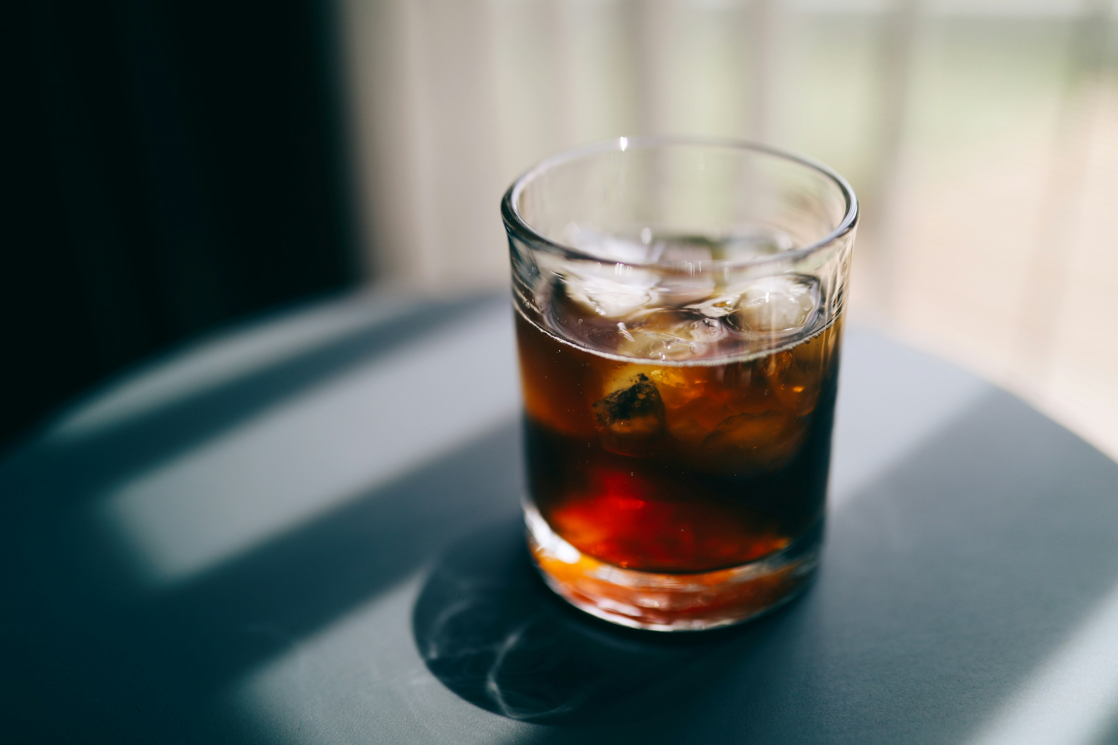 A glass of iced brown drink on a table