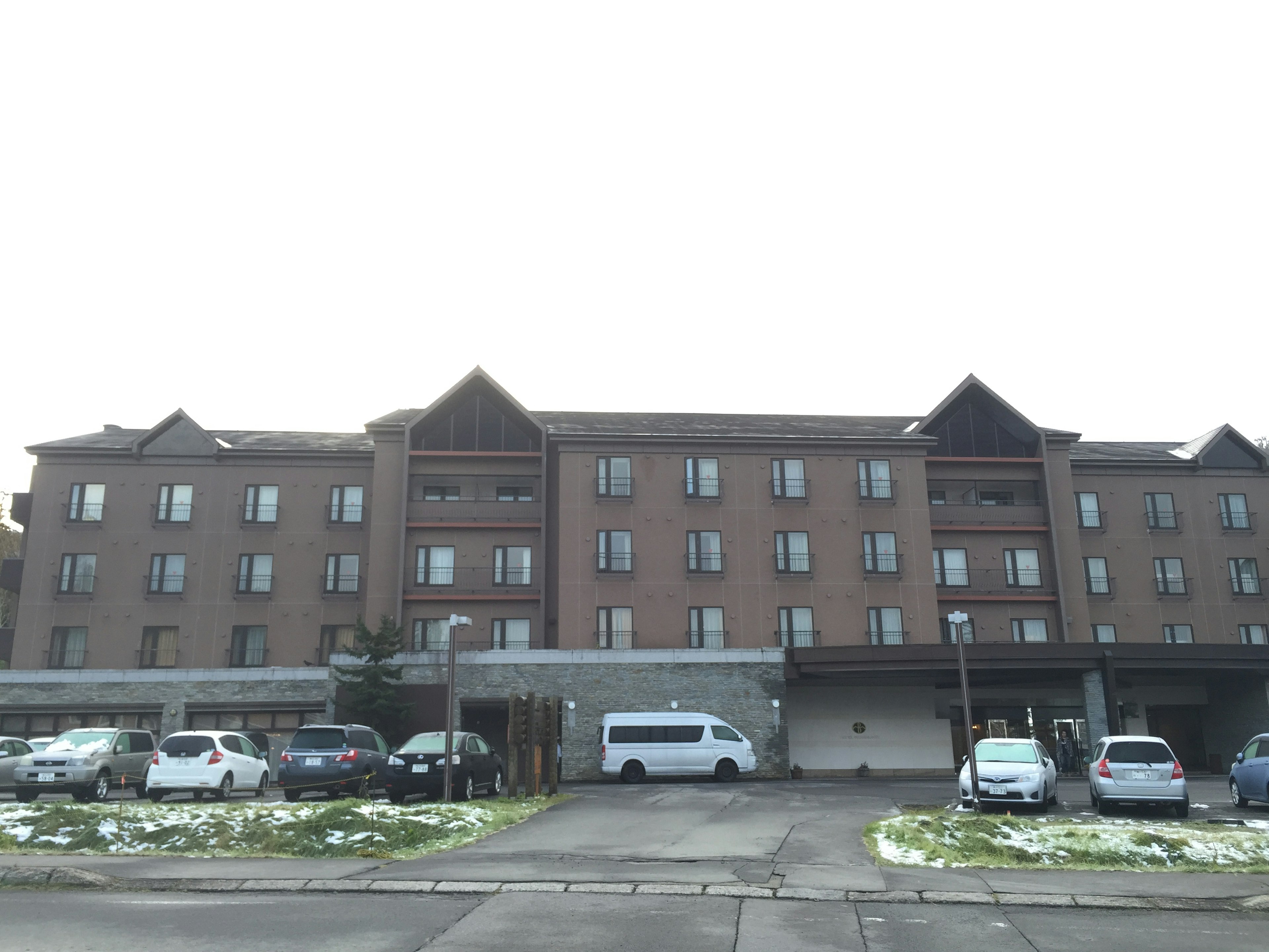 Brick building with multiple windows and snow-covered parking lot