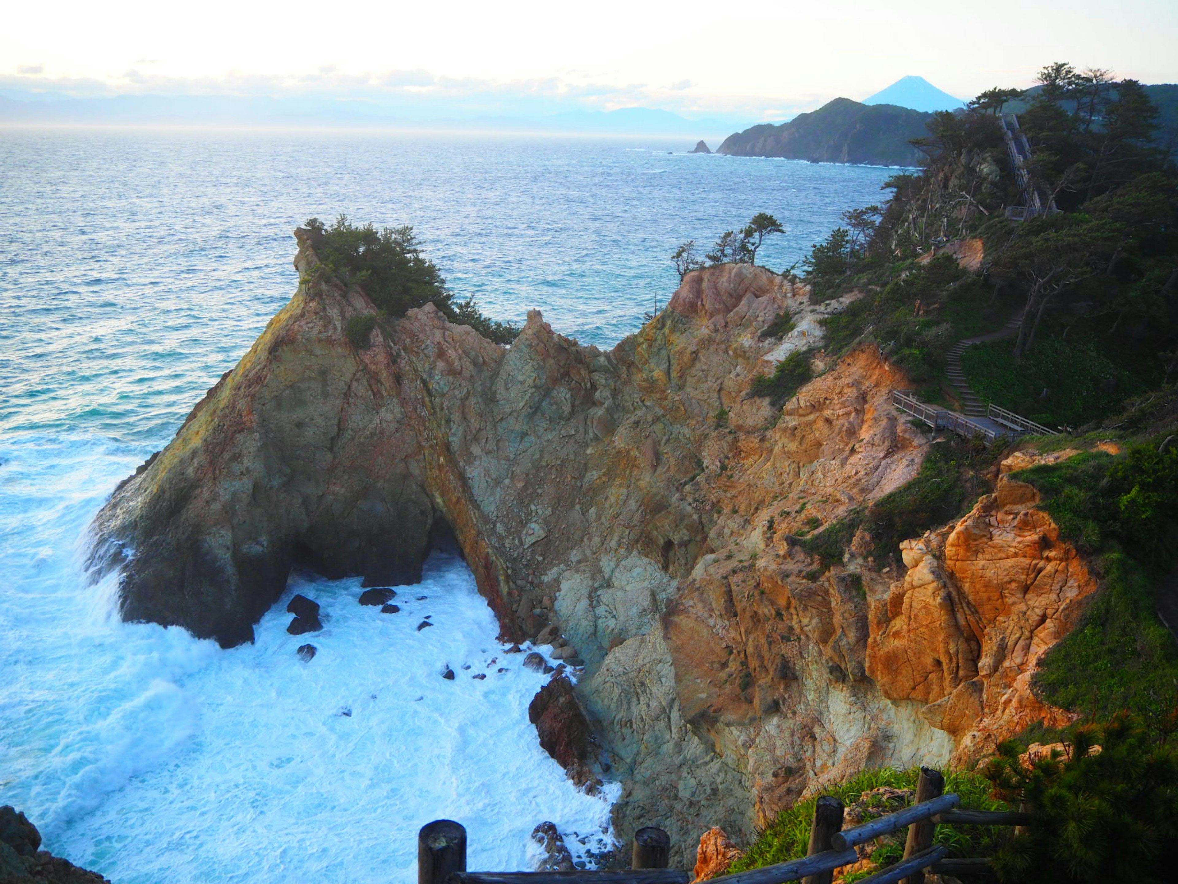 Paysage côtier magnifique avec des falaises rocheuses faisant face à l'océan coucher de soleil illuminant le rivage