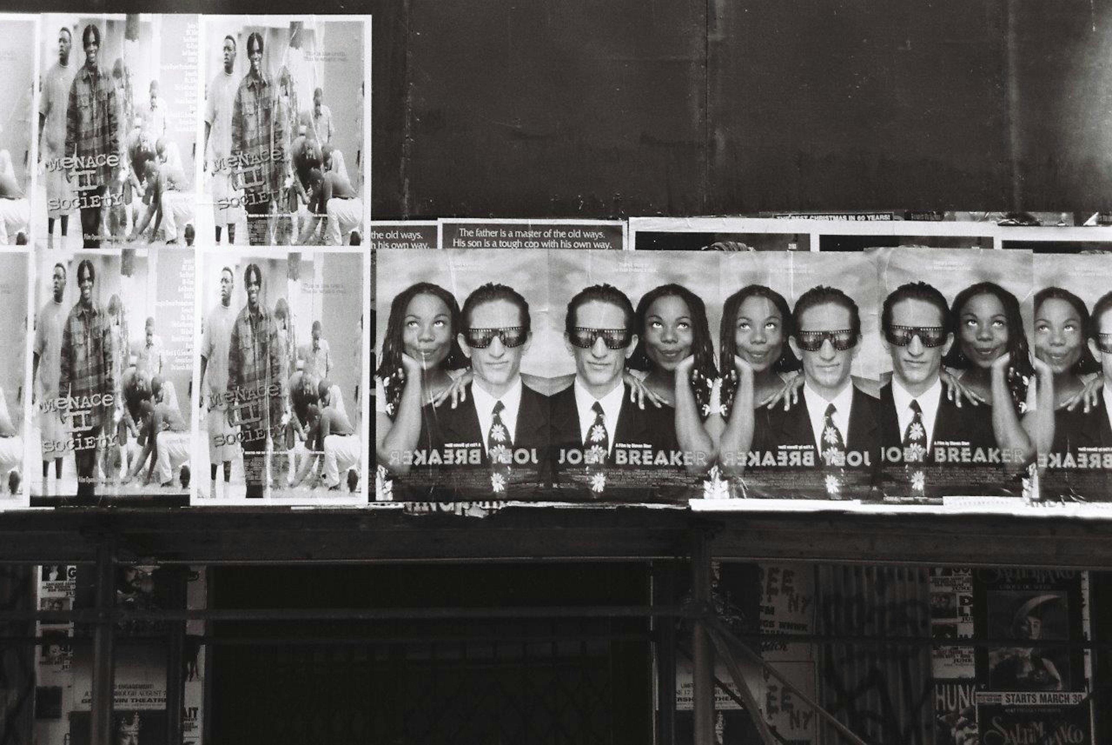 Black and white posters featuring people in suits and sunglasses