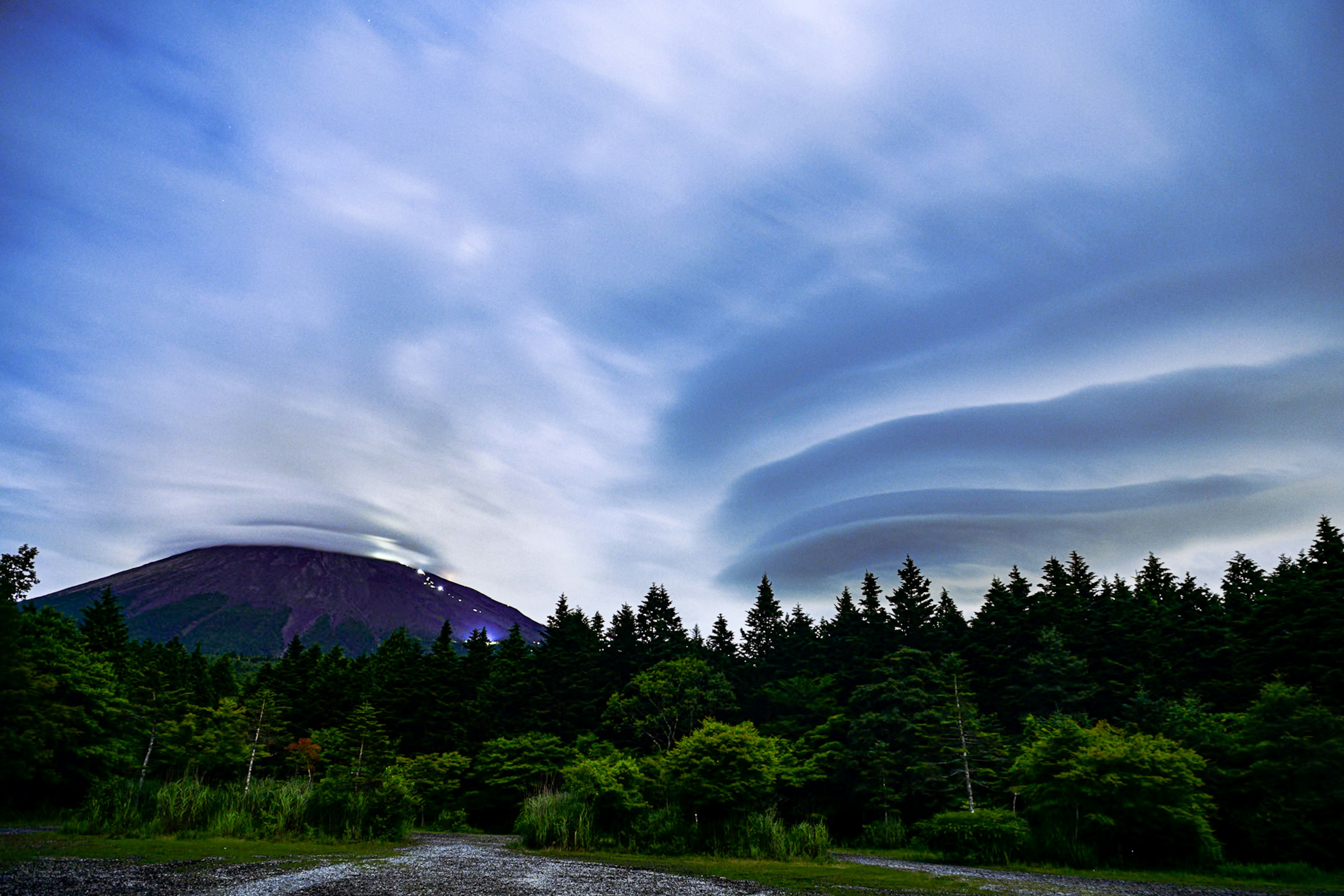 美しい雲が広がる山の風景緑の森と青い空が特徴