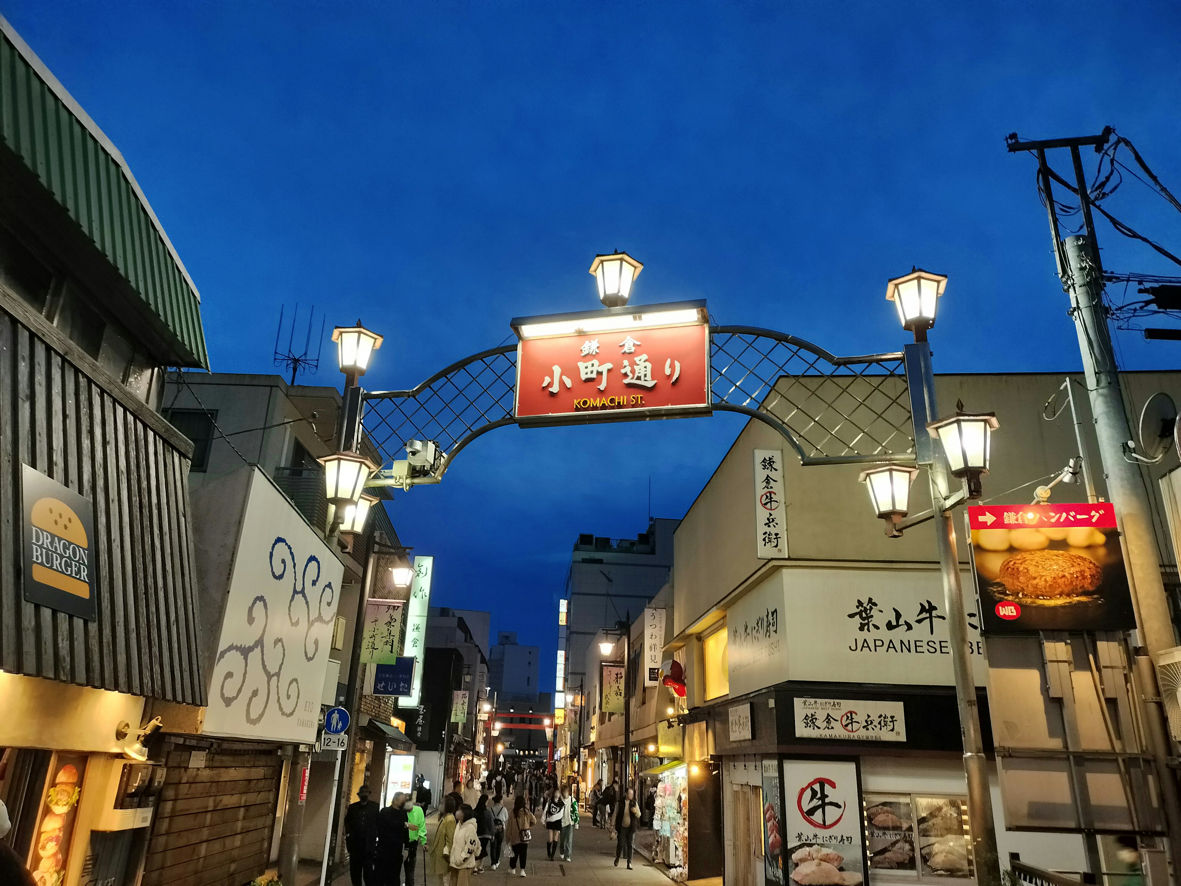 Street view with a sign under a blue sky and lamp posts