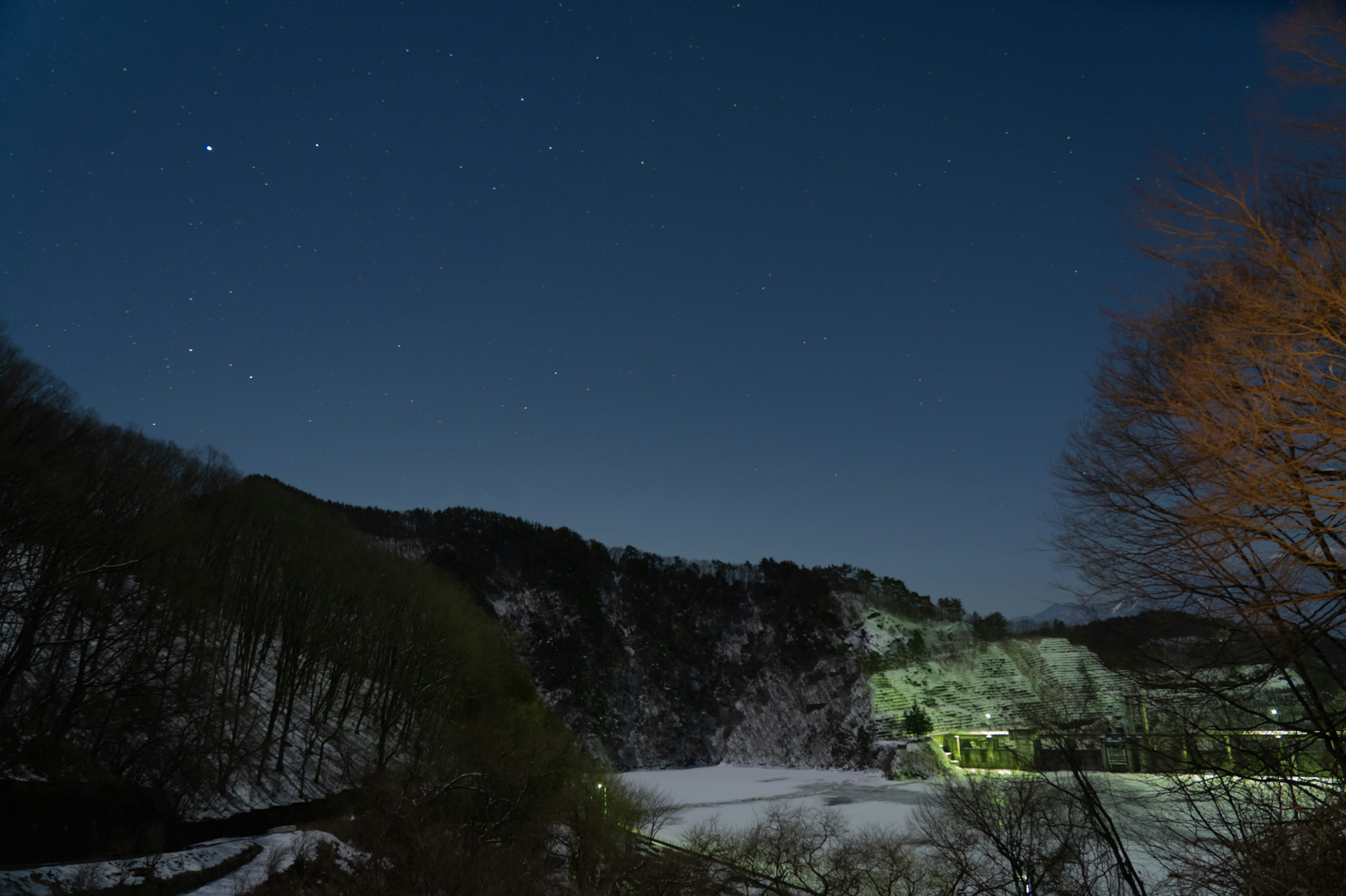 Ciel nocturne avec des étoiles et des montagnes enneigées