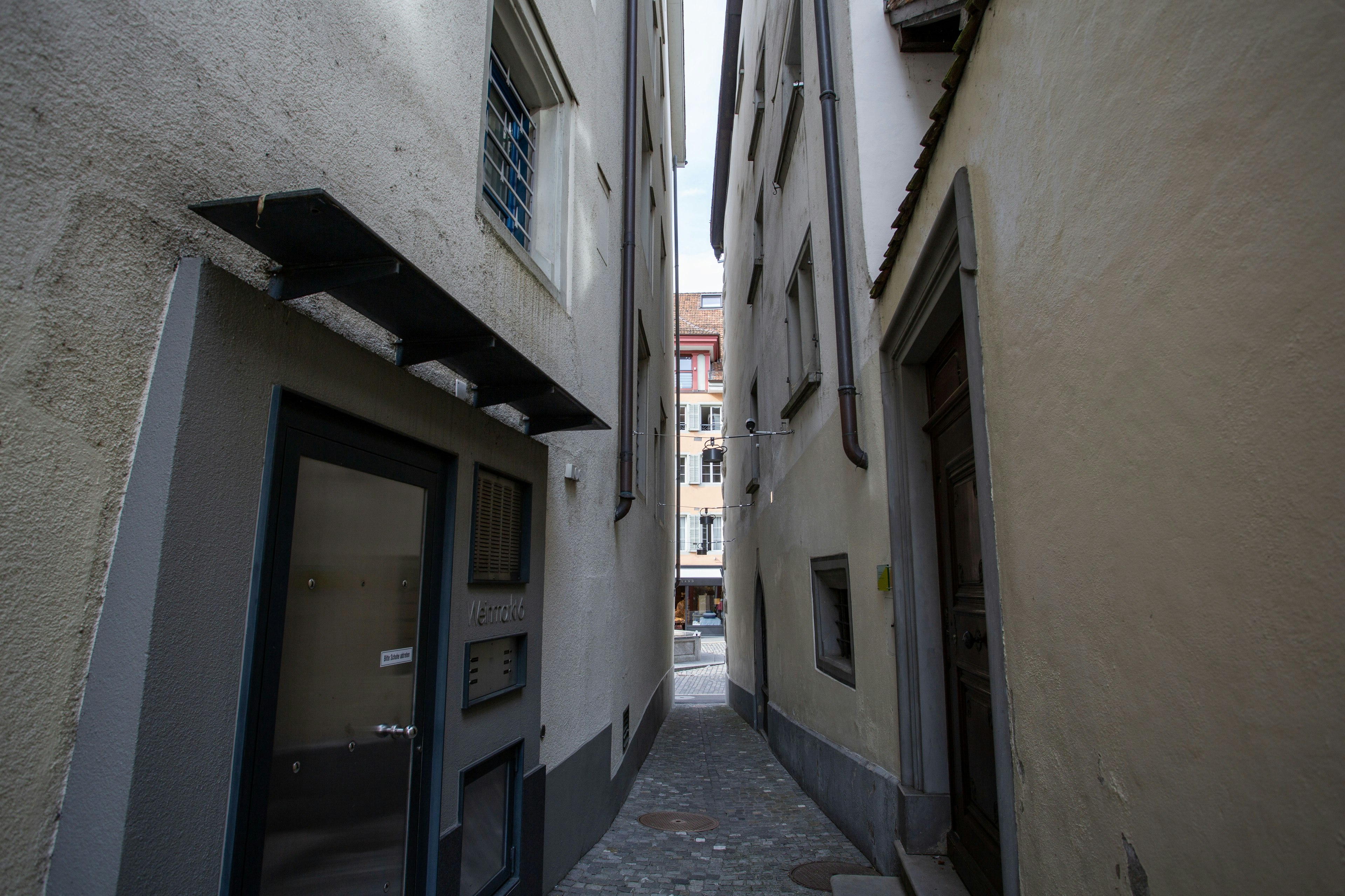 narrow alleyway between old buildings with cobblestone pavement