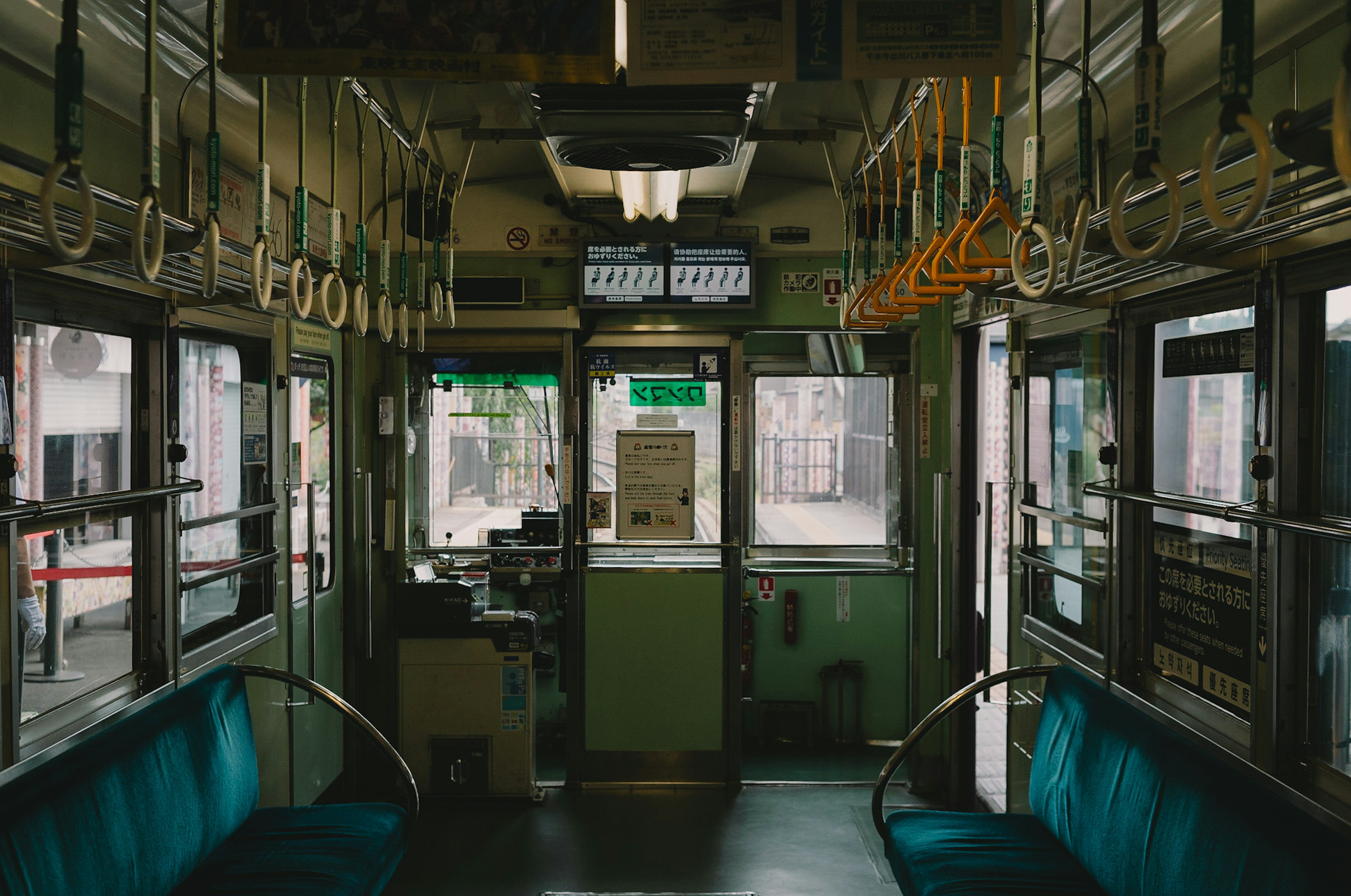 Interior of a green train with seats and handrails