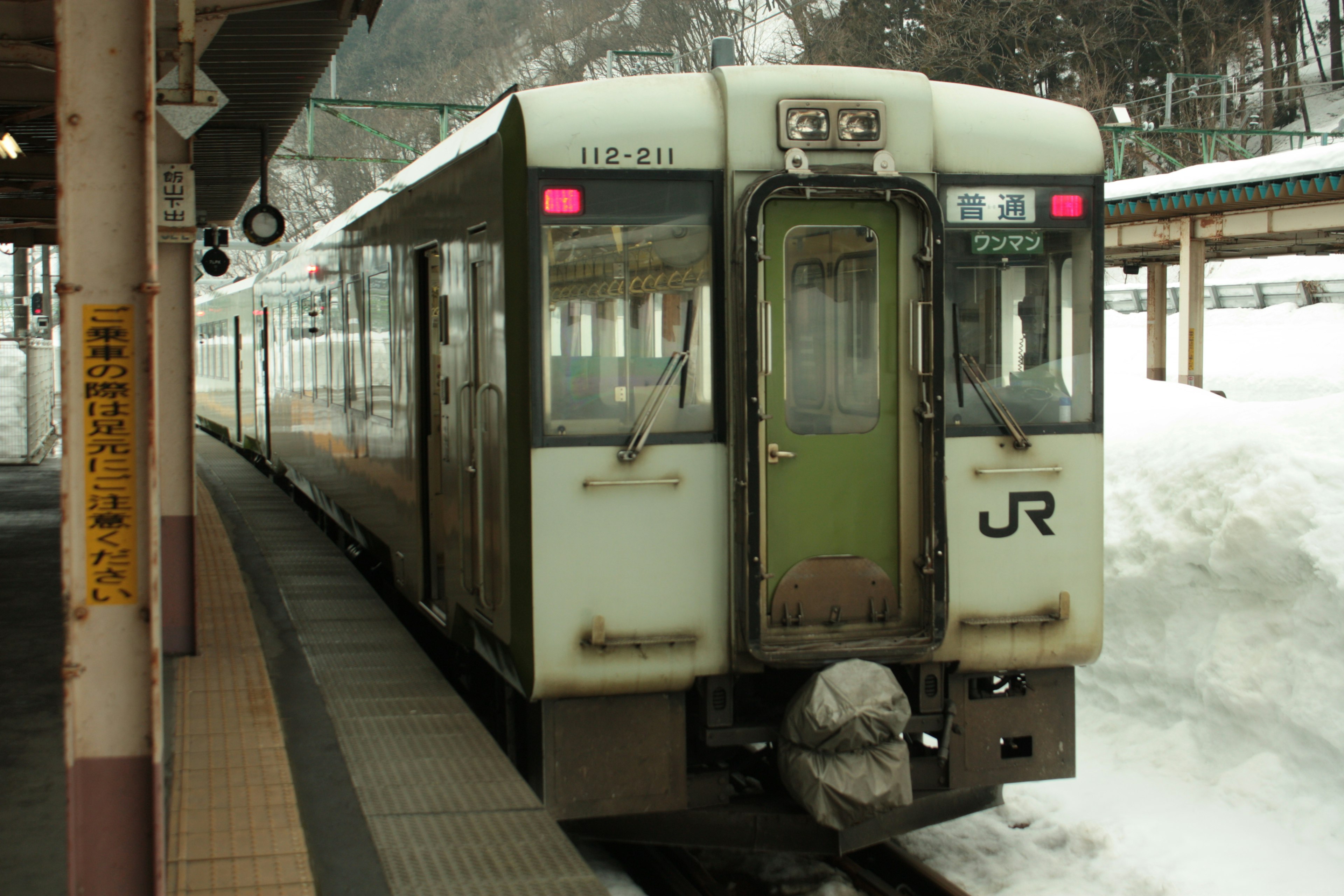 Treno JR fermo in una stazione innevata