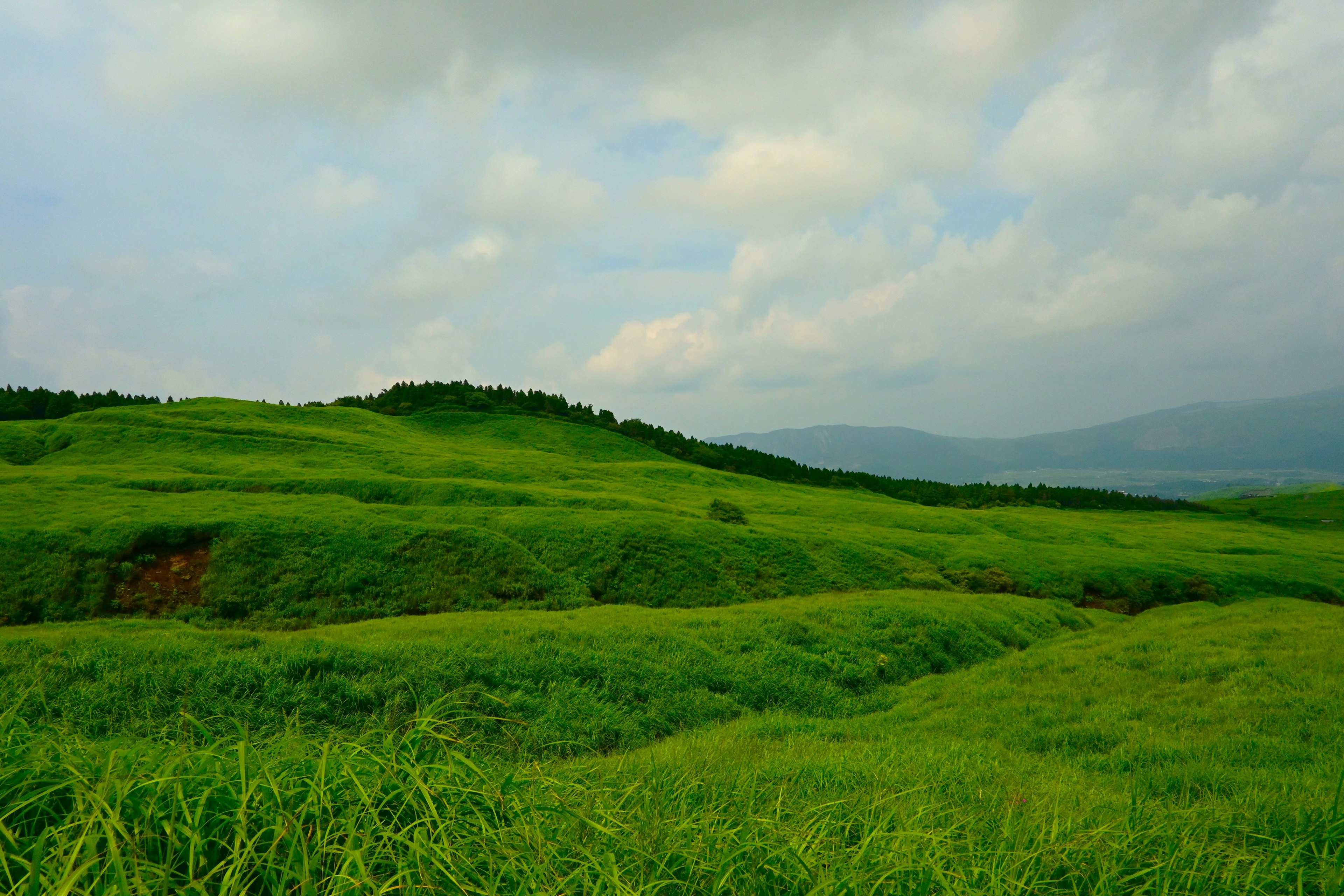 Lush green hills under a cloudy sky