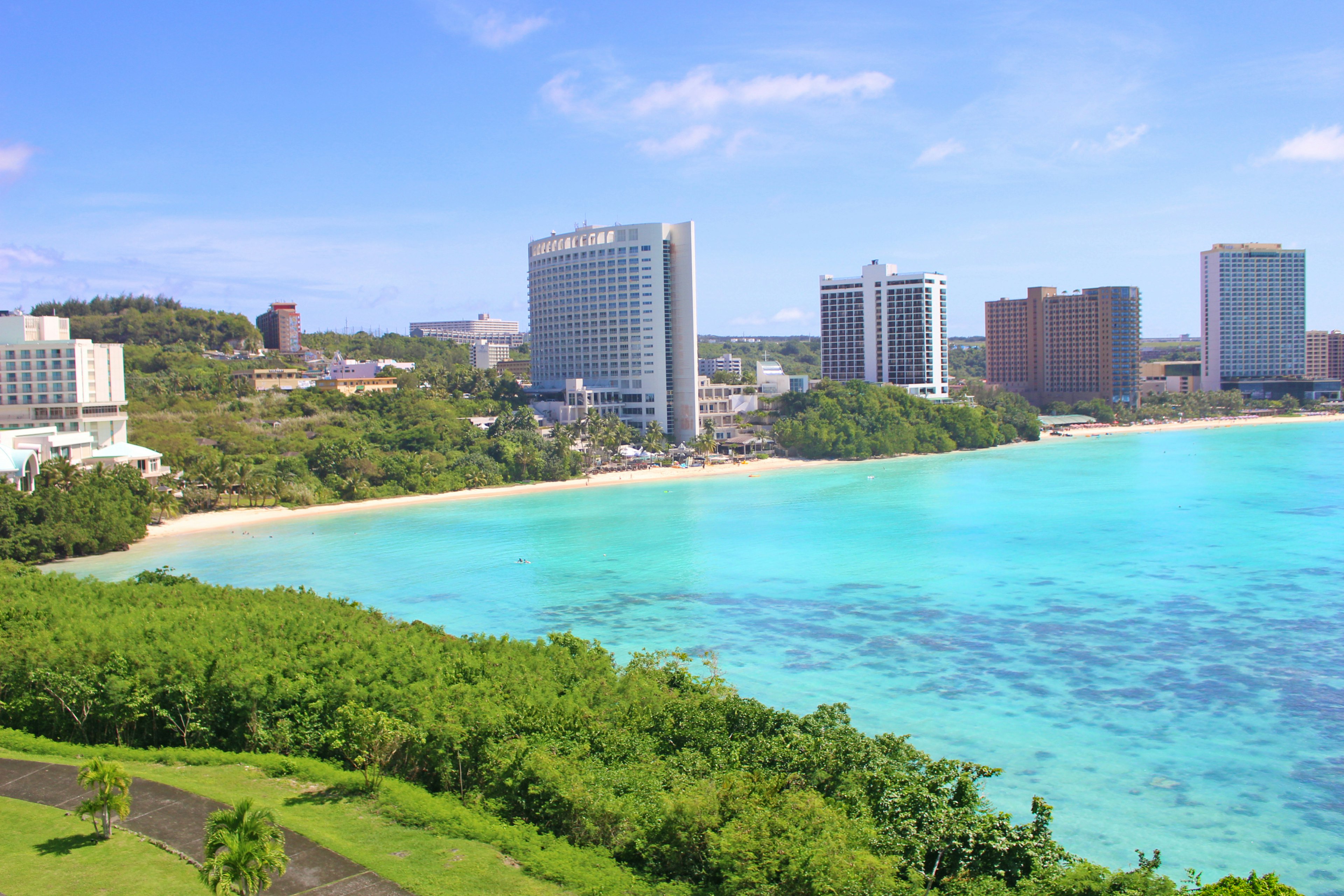 Pemandangan pantai yang indah dengan lautan biru dan gedung pencakar langit