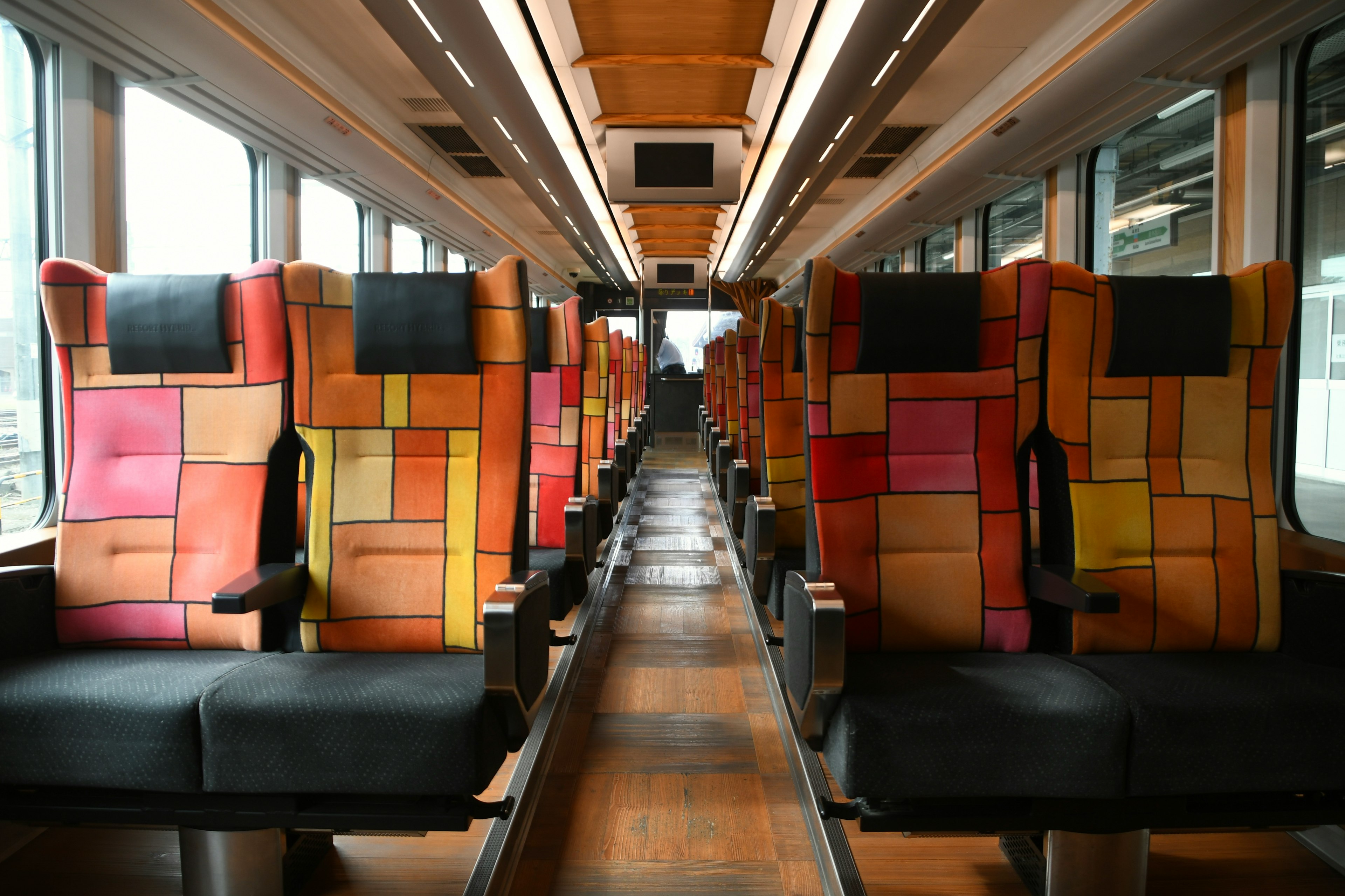 Interior view of a train carriage with colorful patterned seats