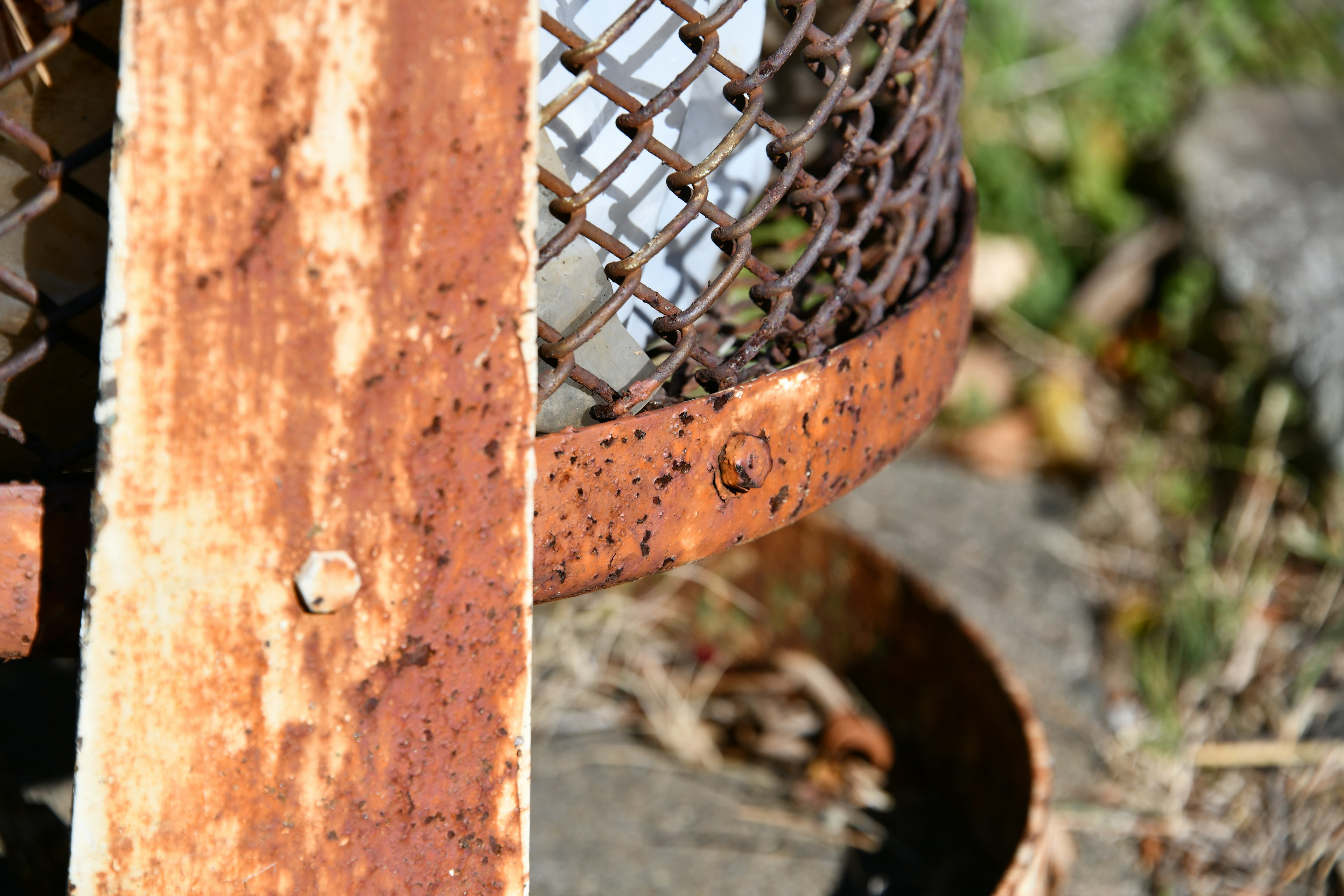 Primer plano de una cesta de metal oxidada y una tabla de madera