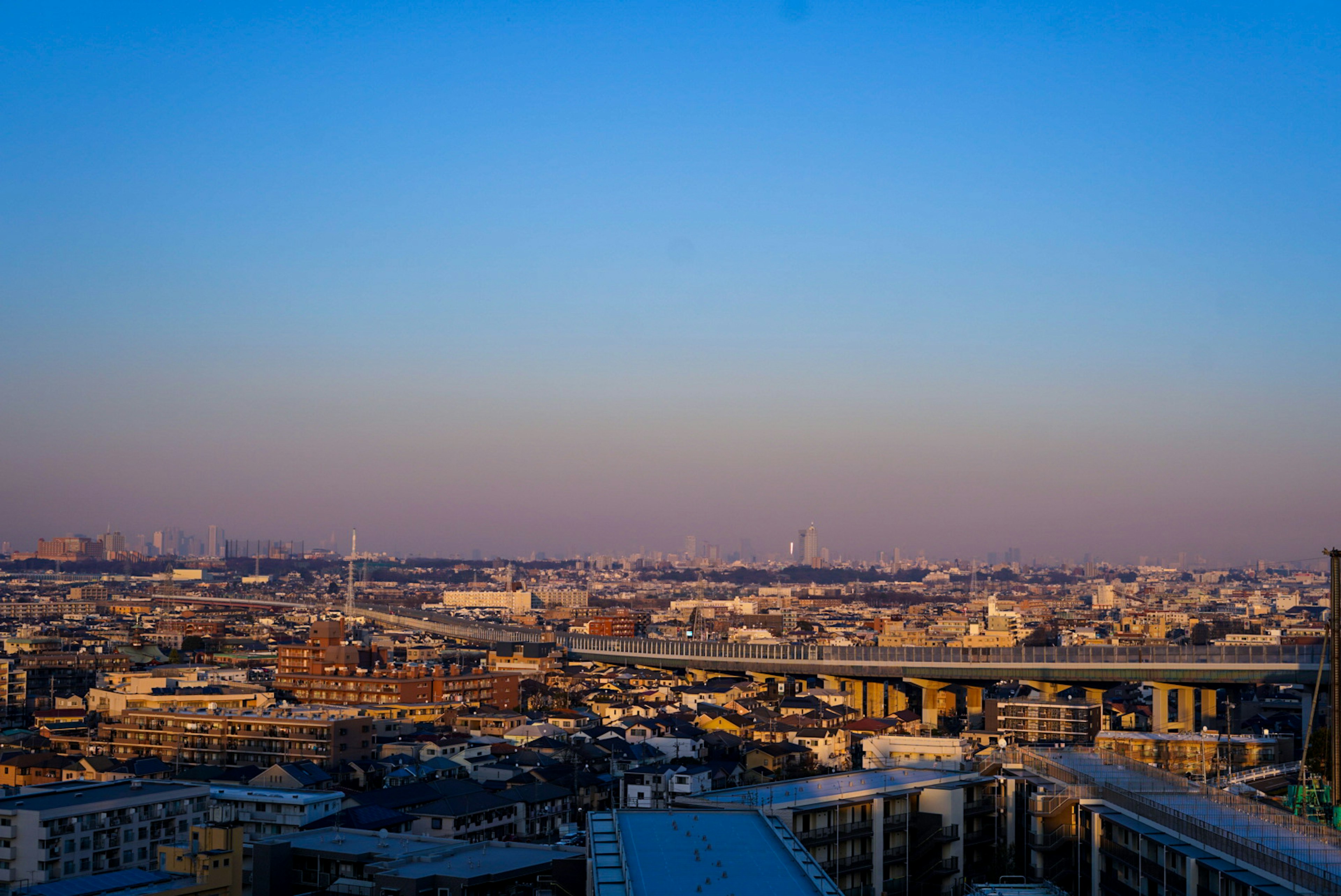 夕暮れ時の都市の風景広がる青い空と建物群