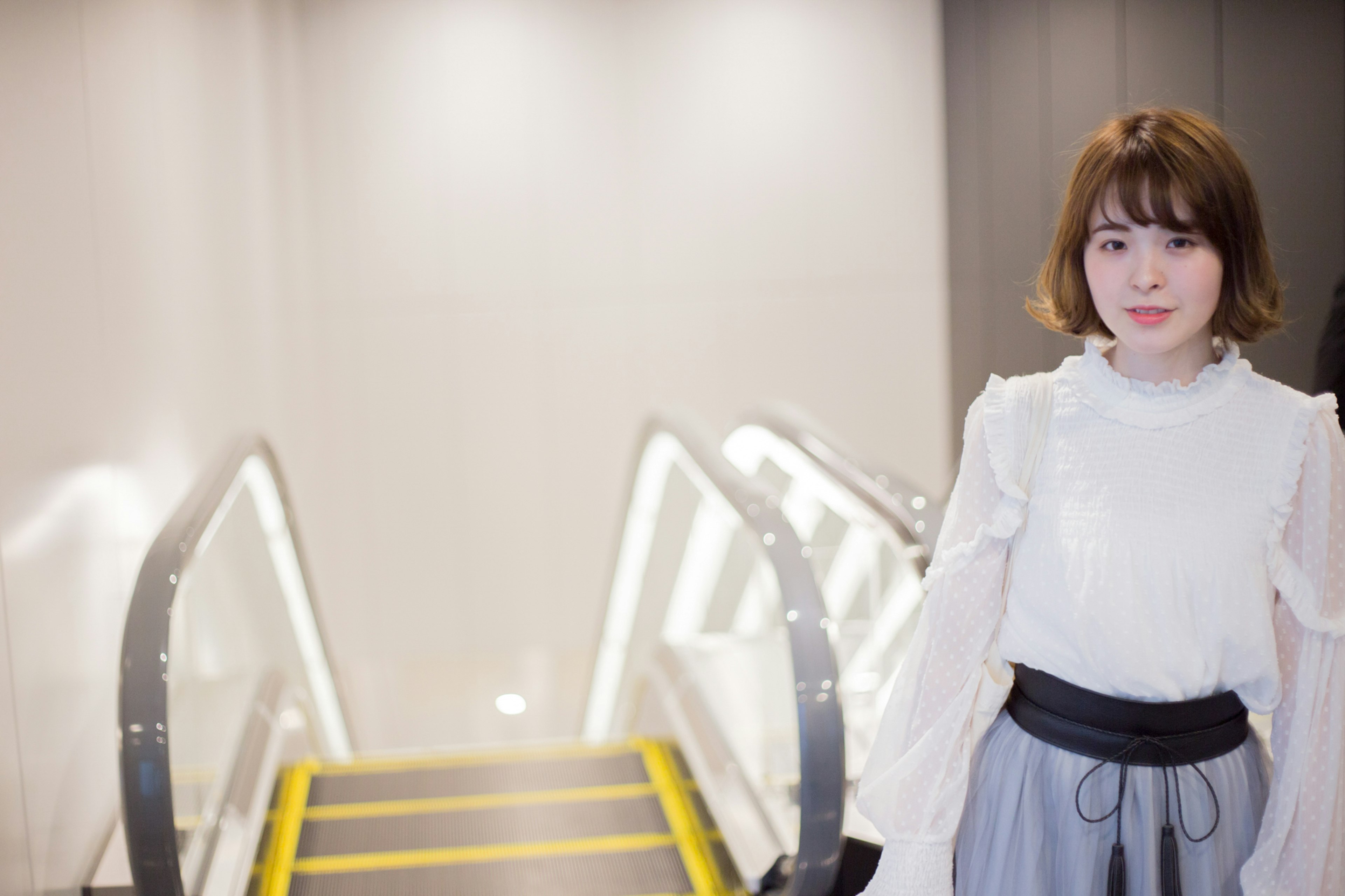 Retrato de una mujer de pie frente a escaleras fondo brillante y diseño moderno