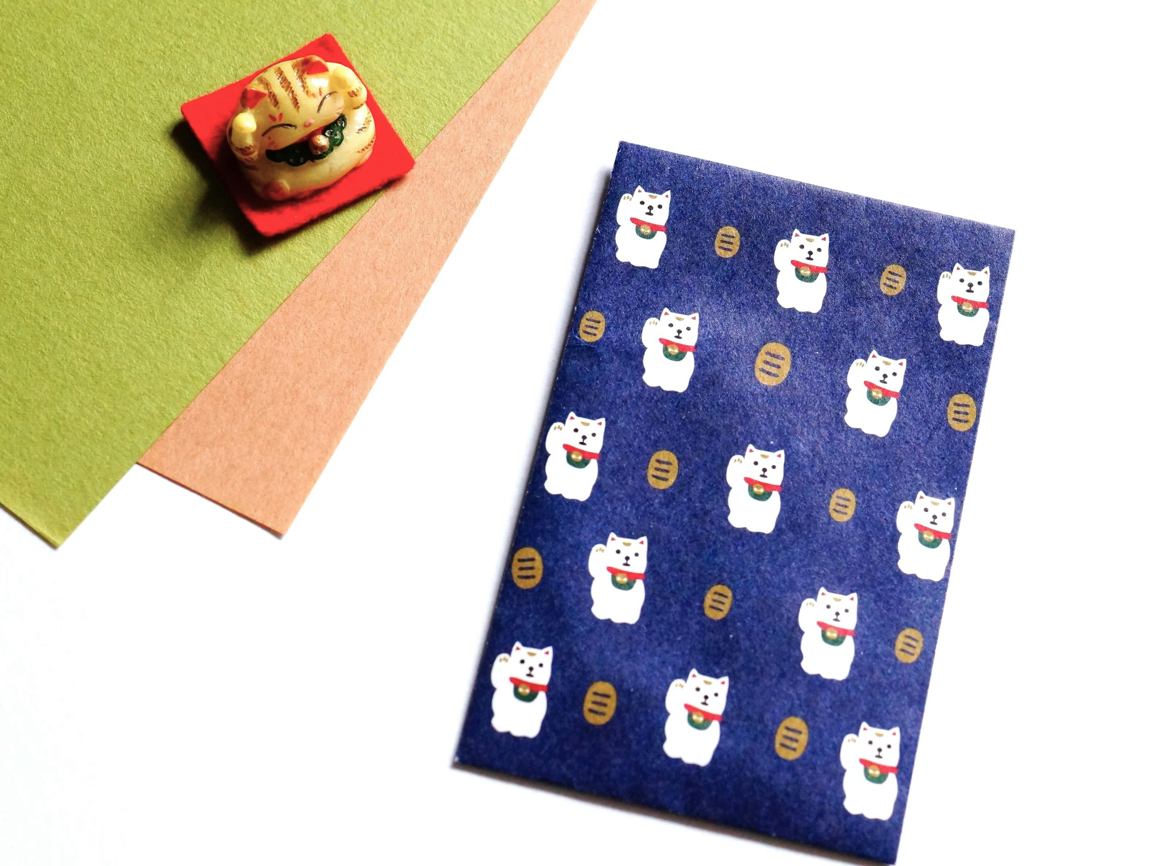 A notebook with cat designs on a blue background accompanied by traditional sweets