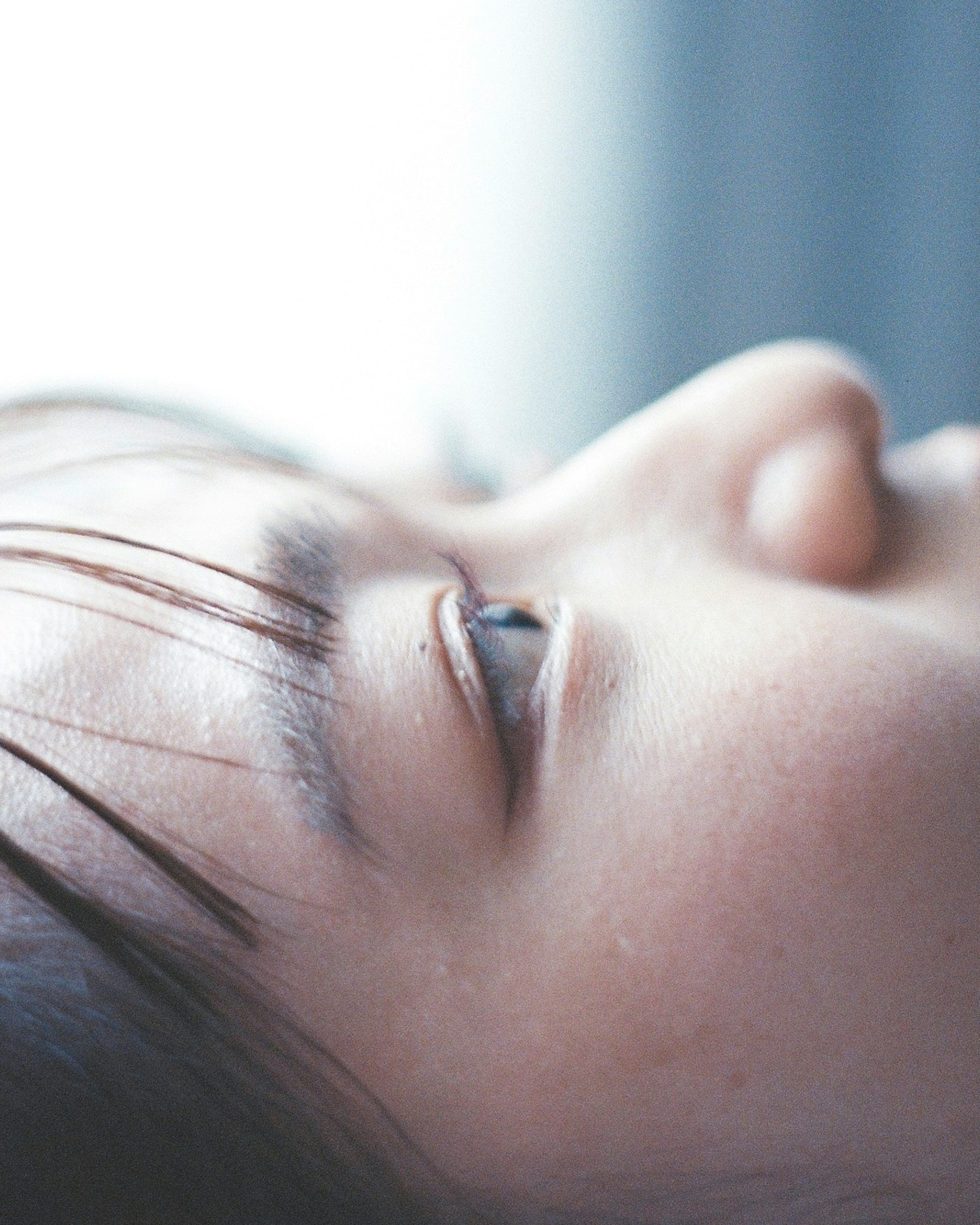 Close-up of a woman's profile illuminated by soft window light