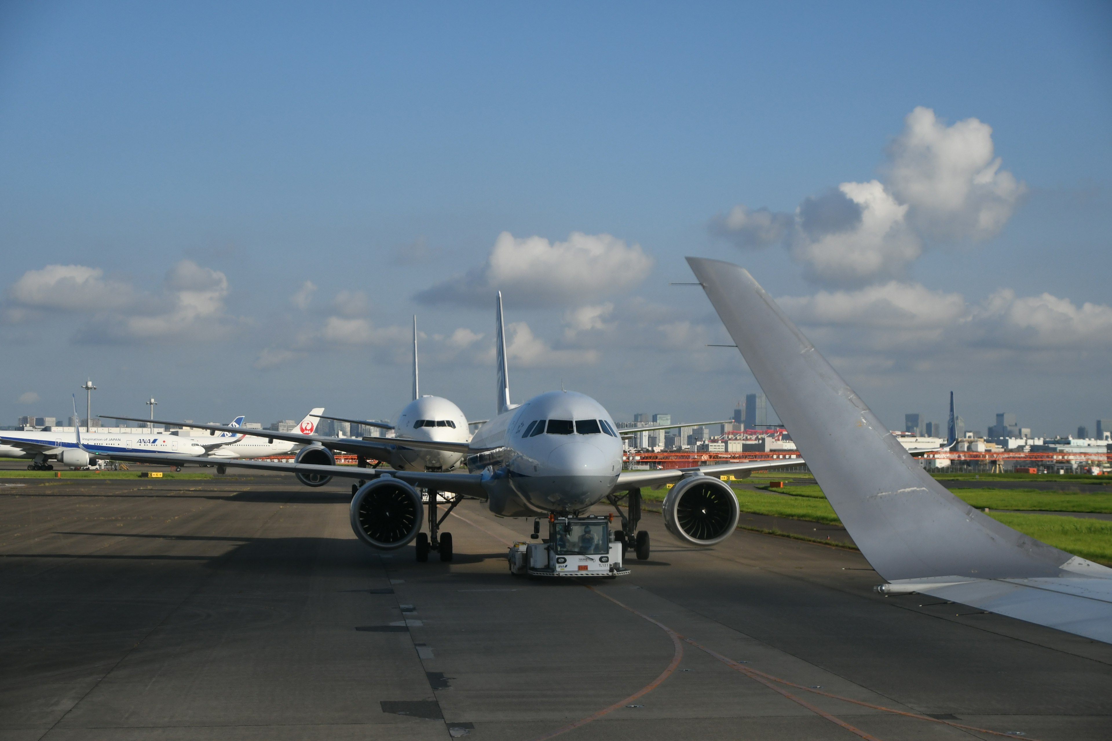 View of aircraft on runway with wing in foreground