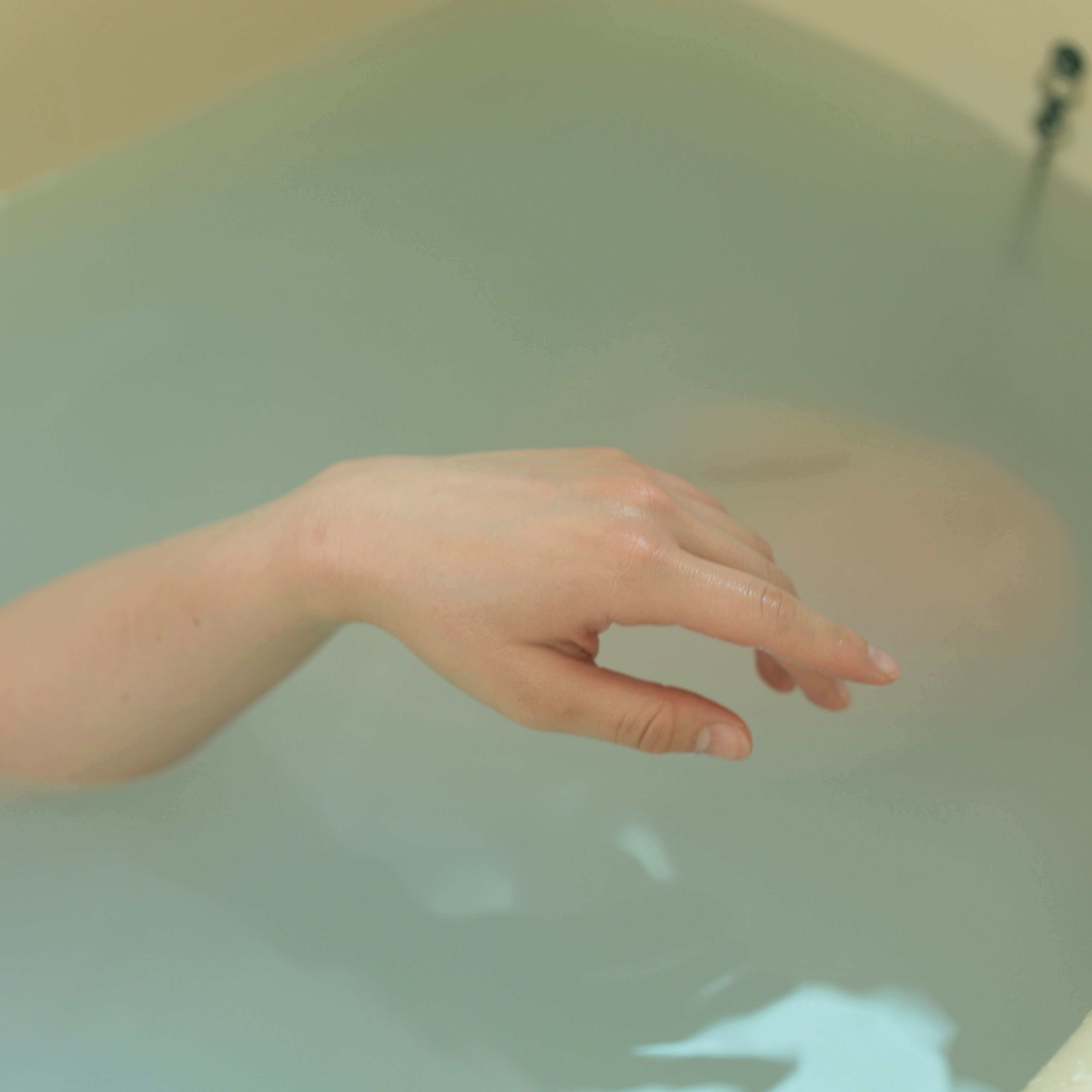 A serene moment with a hand gently touching the water