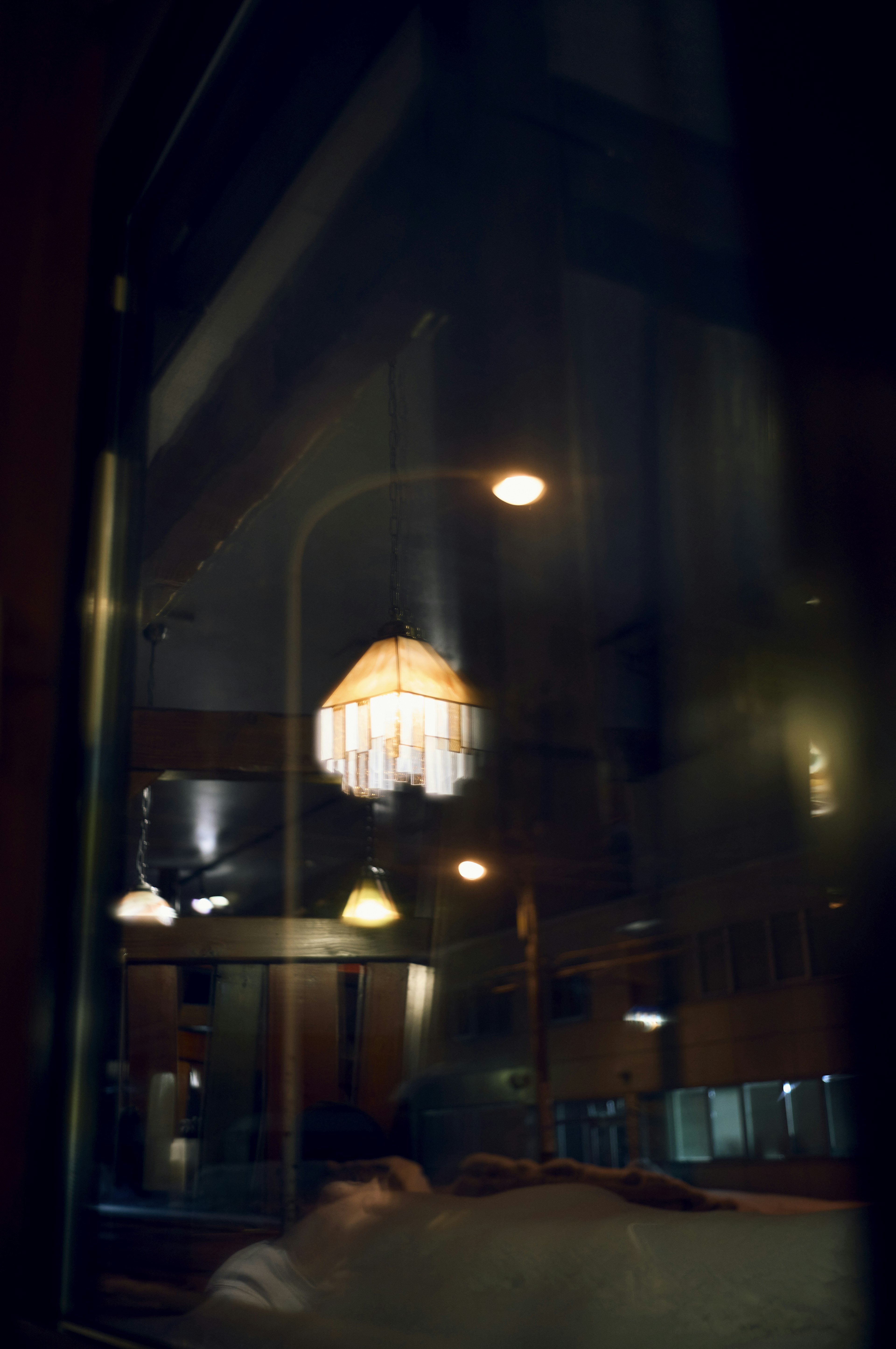 Soft reflections of a lamp and ambient lights seen through a window