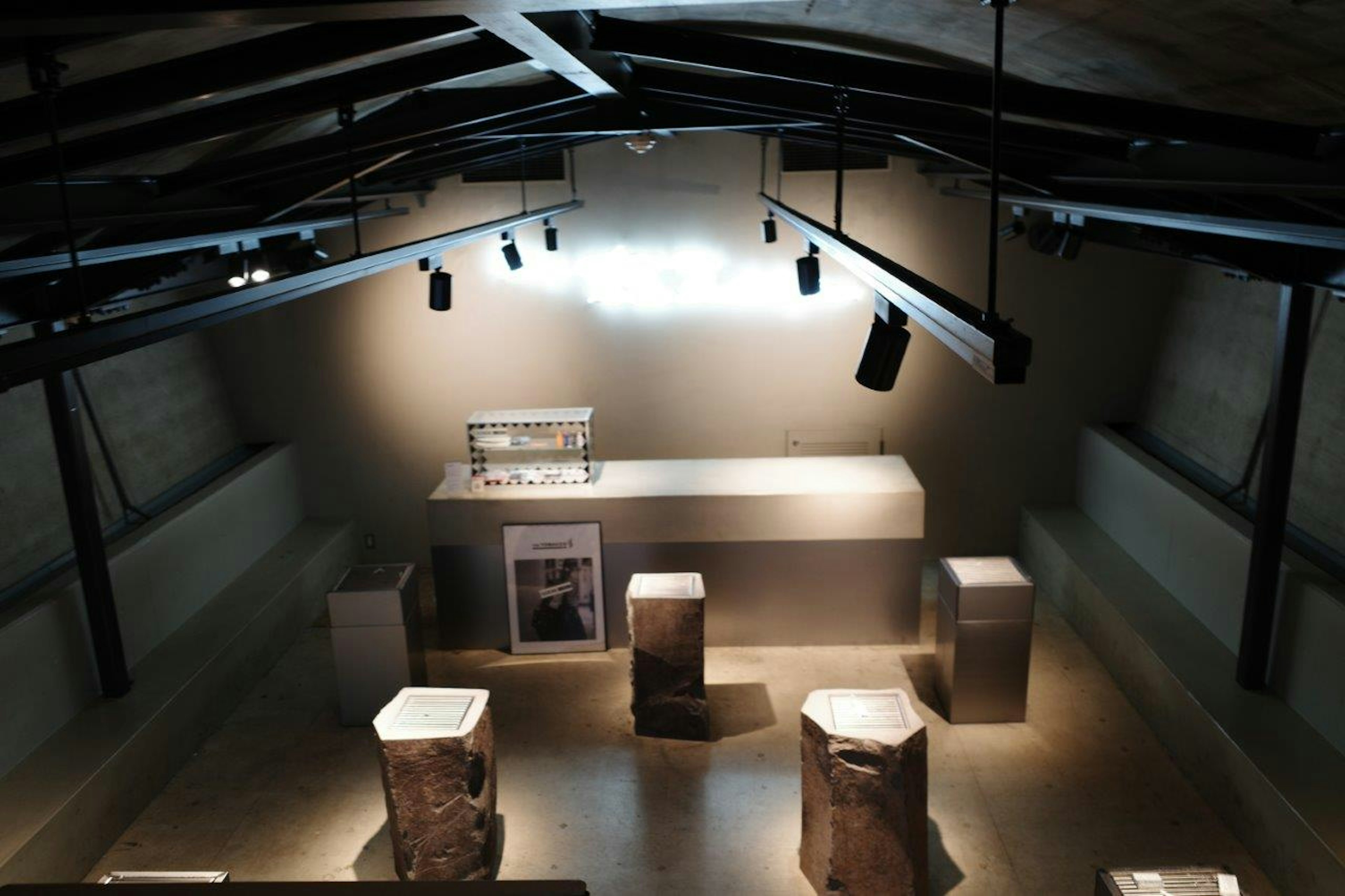 Overhead view of an exhibition space featuring a central display and surrounding pedestals