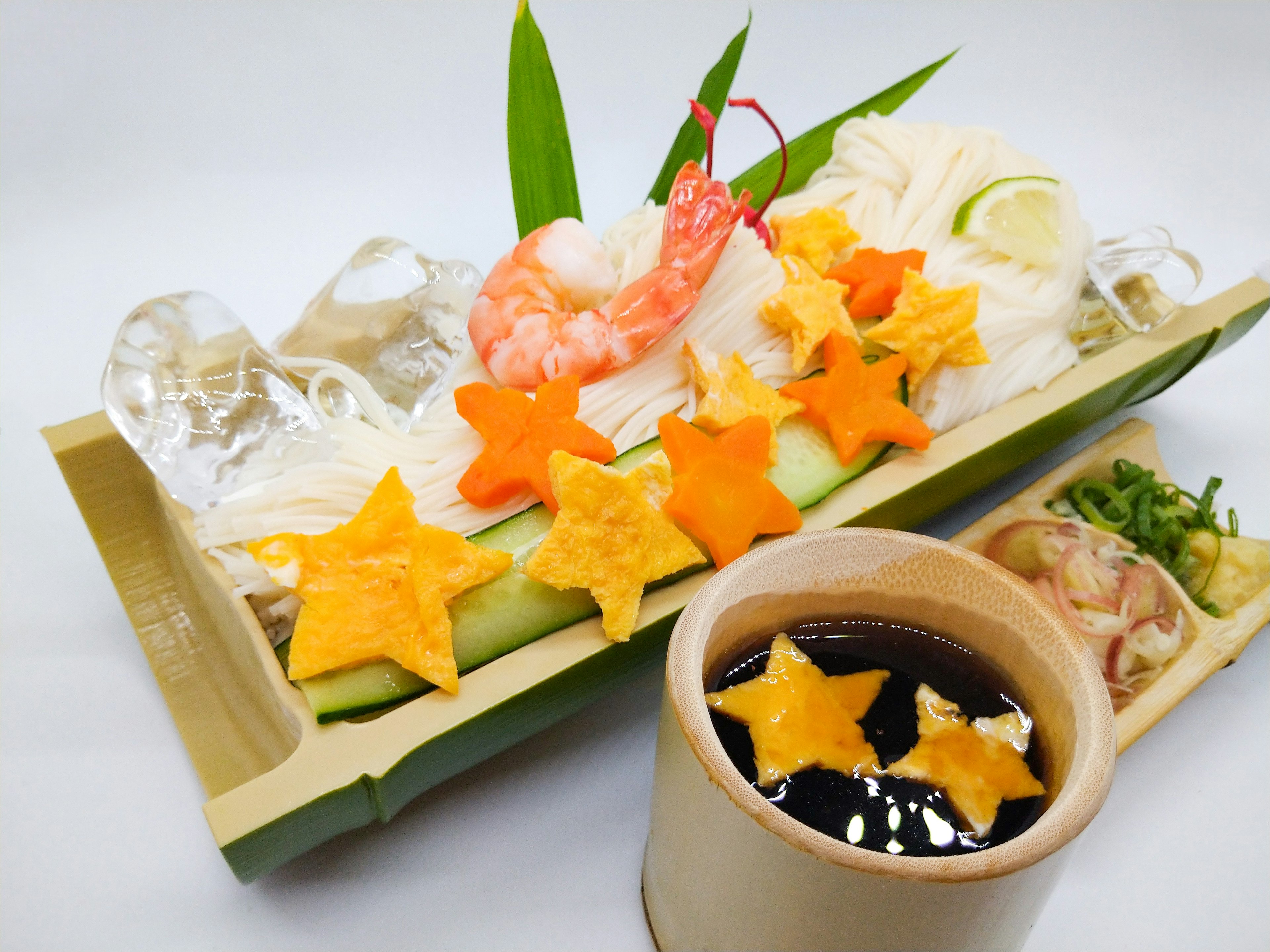 Un plateau de sushi joliment présenté avec des crevettes et des légumes en forme d'étoile