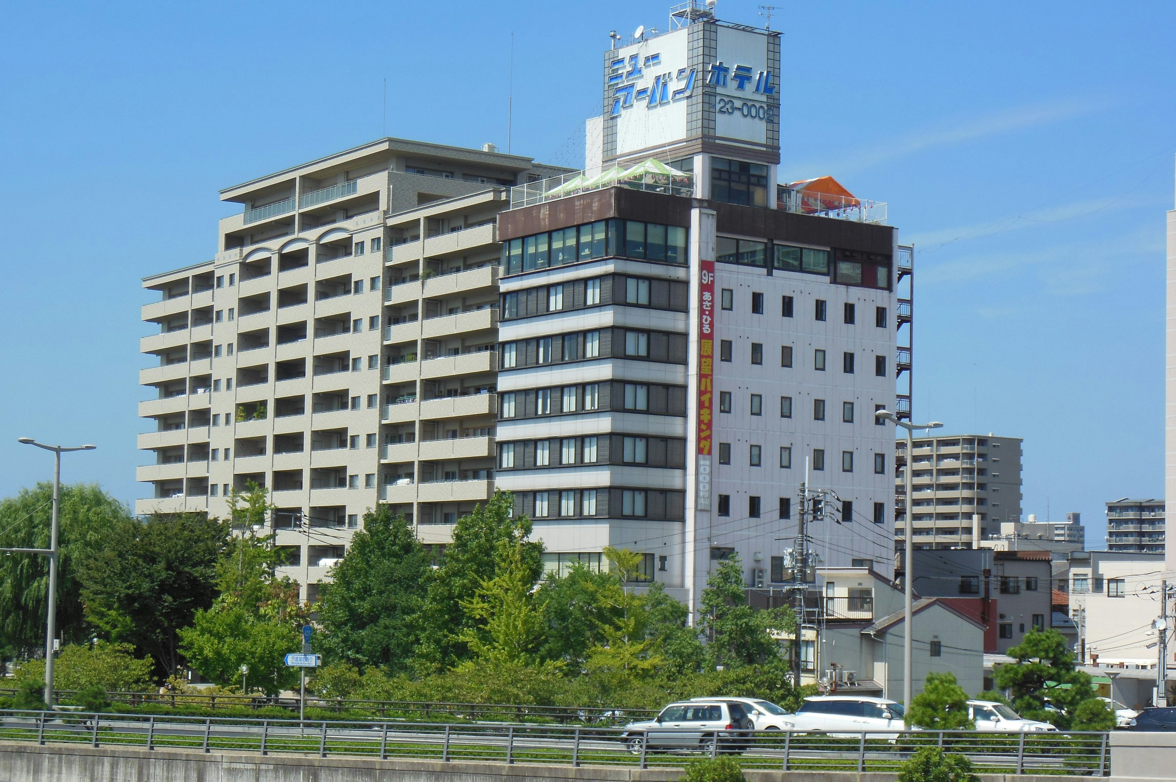 Modern buildings under a clear blue sky with green trees