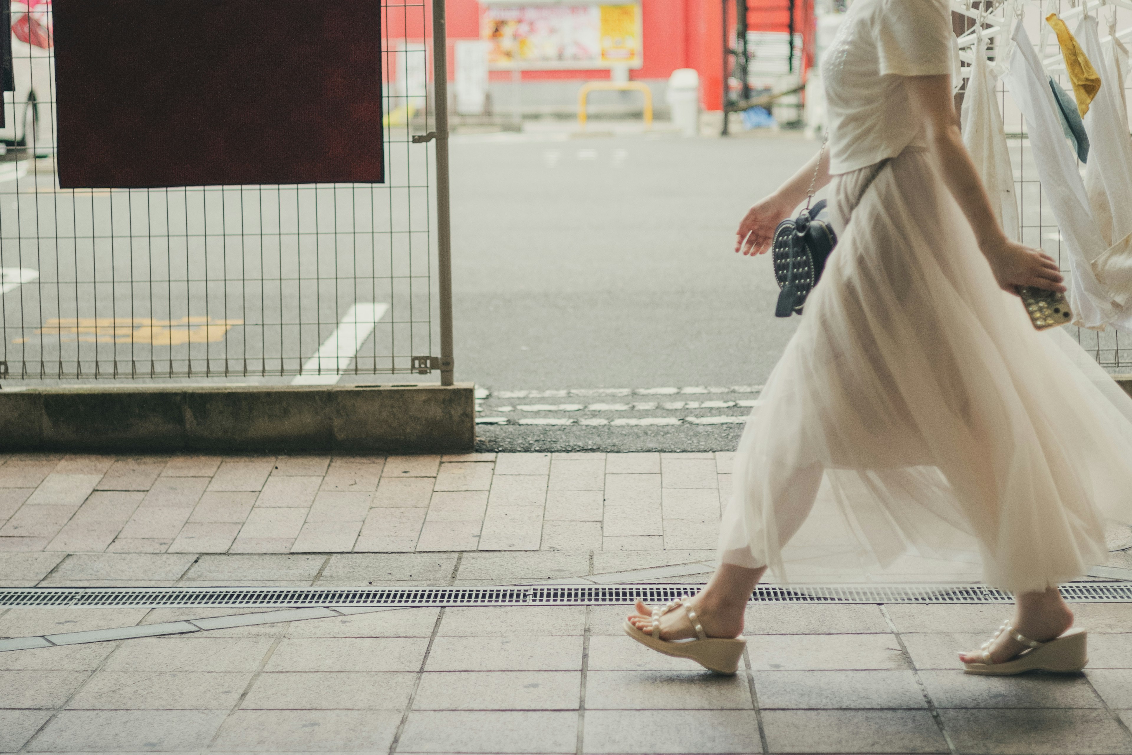 女性が白いスカートを履いて歩いている街の風景