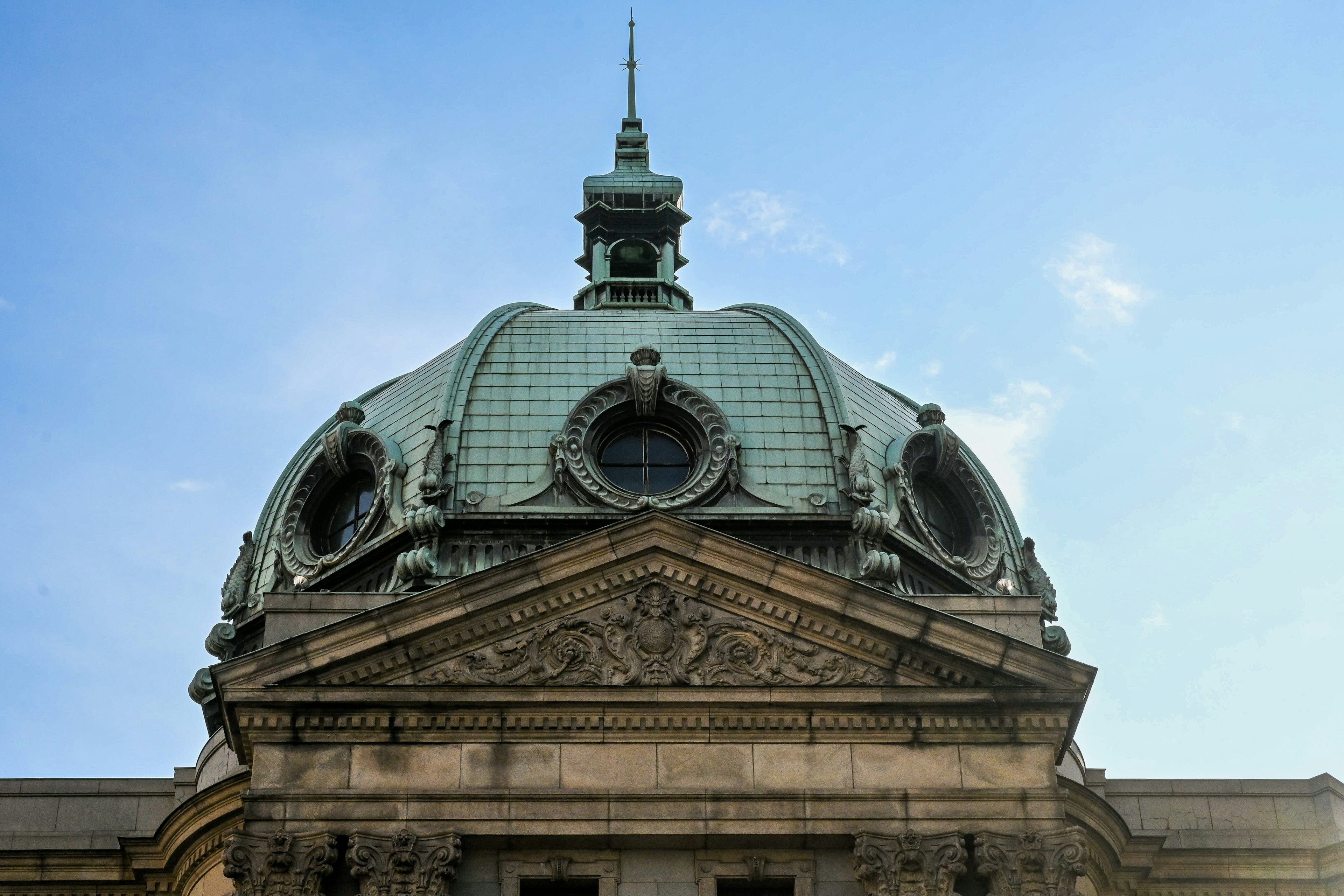 Architectural dome with green copper roof and ornate sculptures