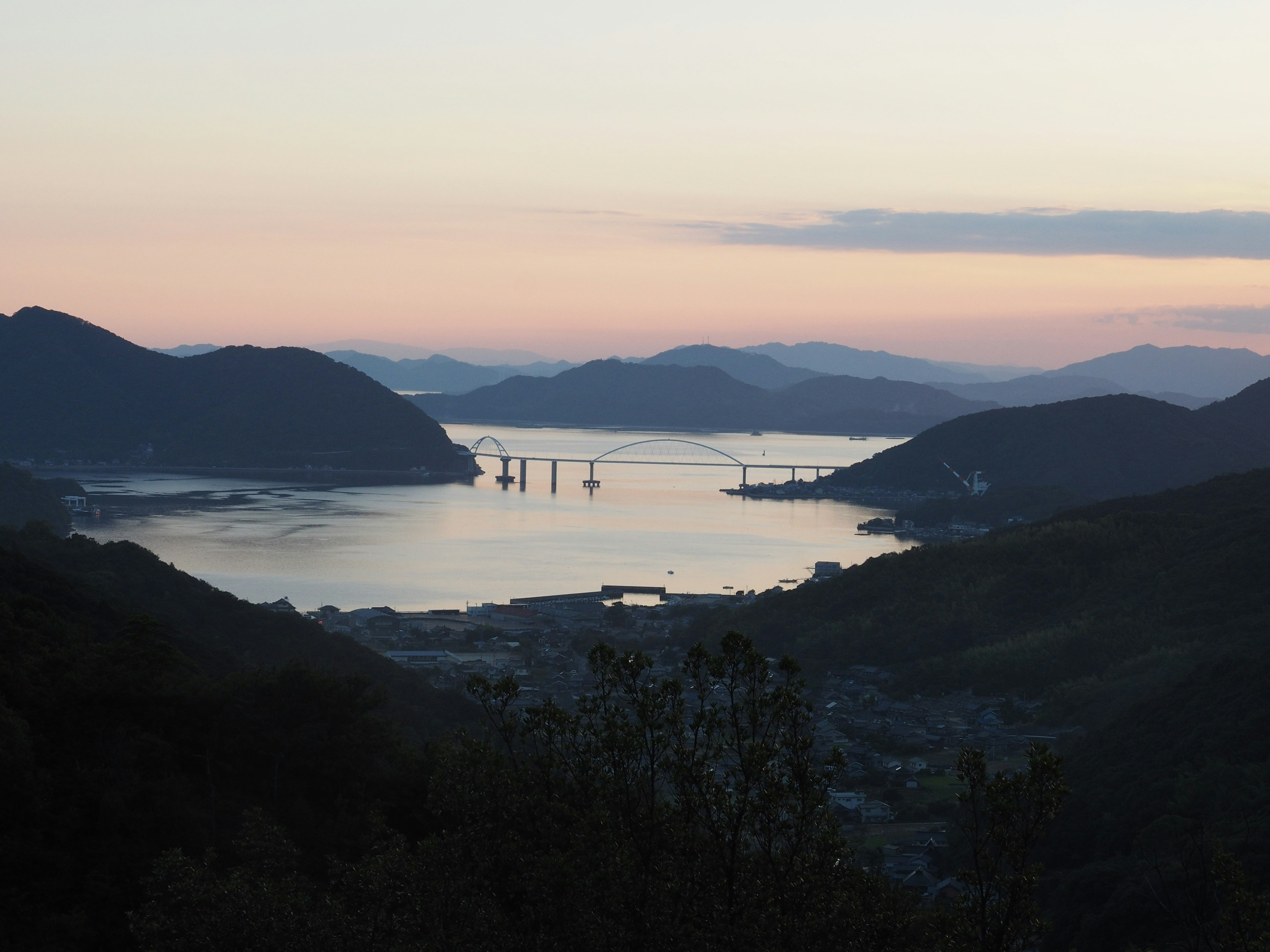 夕暮れの海と山の景色橋が見える