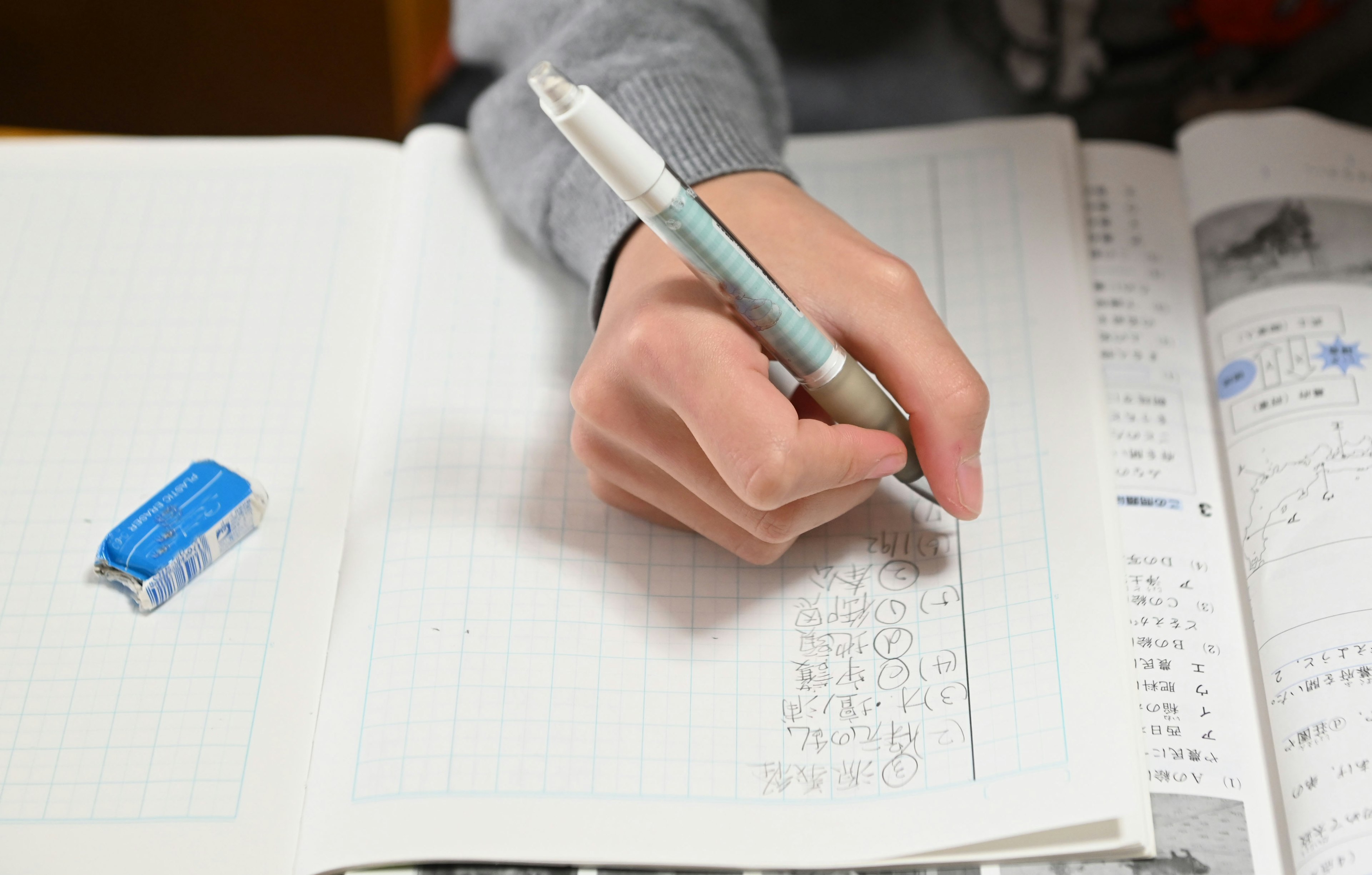 A student's hand writing in a notebook