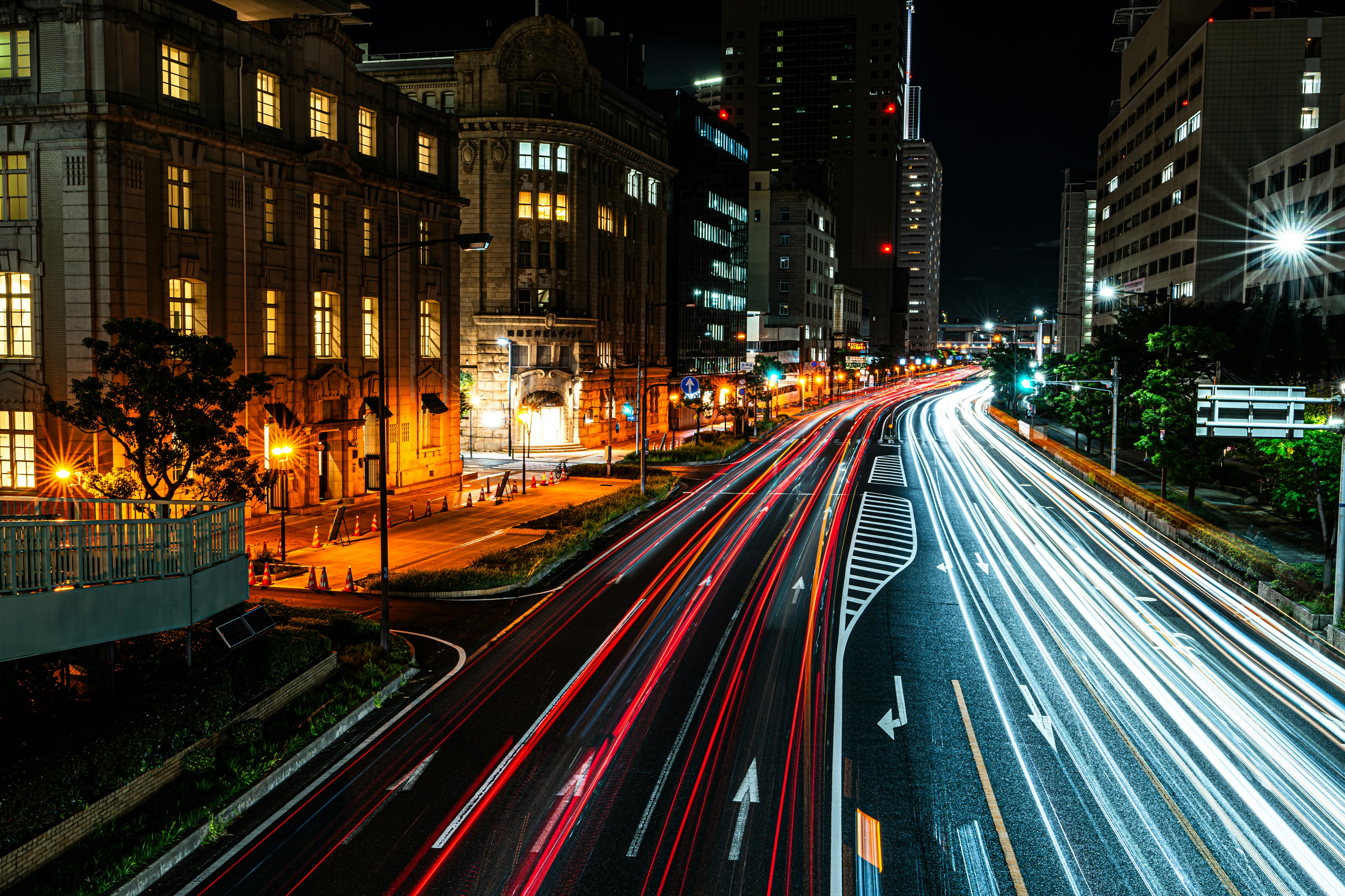 夜の都市風景 車のライトが流れる道路 明るい街灯とビルが立ち並ぶ