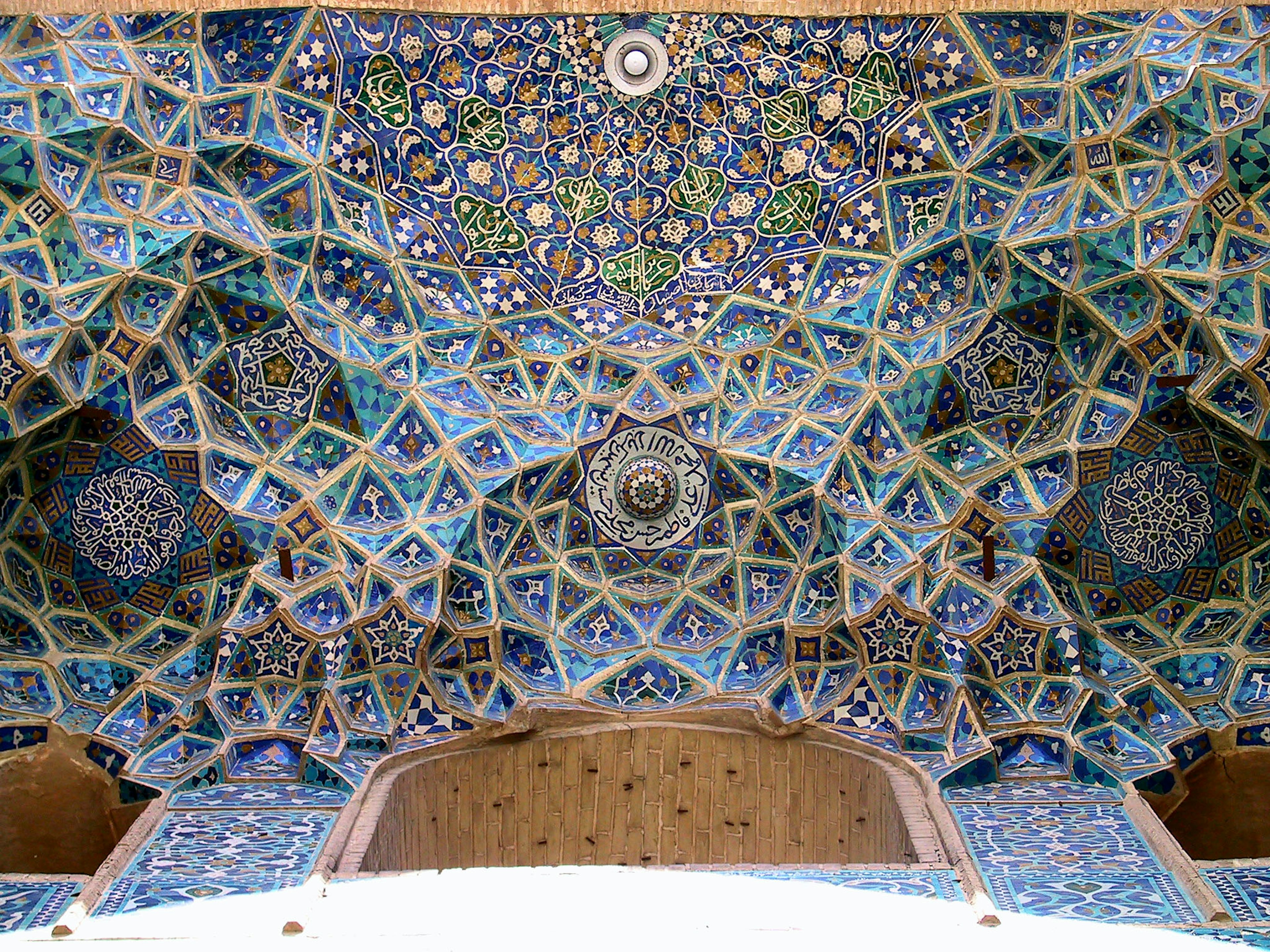 Intricate ceiling with colorful tile work featuring blue and gold hues surrounded by geometric patterns