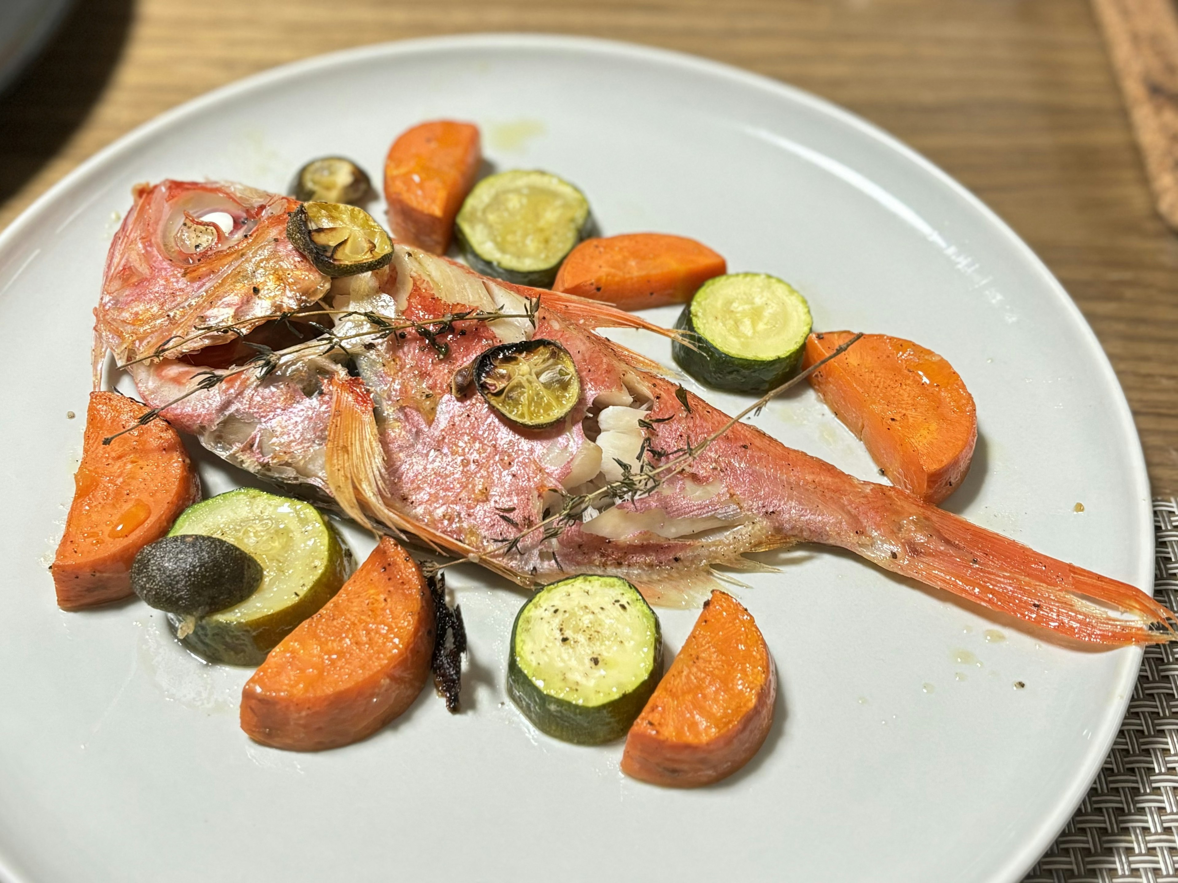 Gebratener roter Fisch mit Karotten und Zucchini serviert