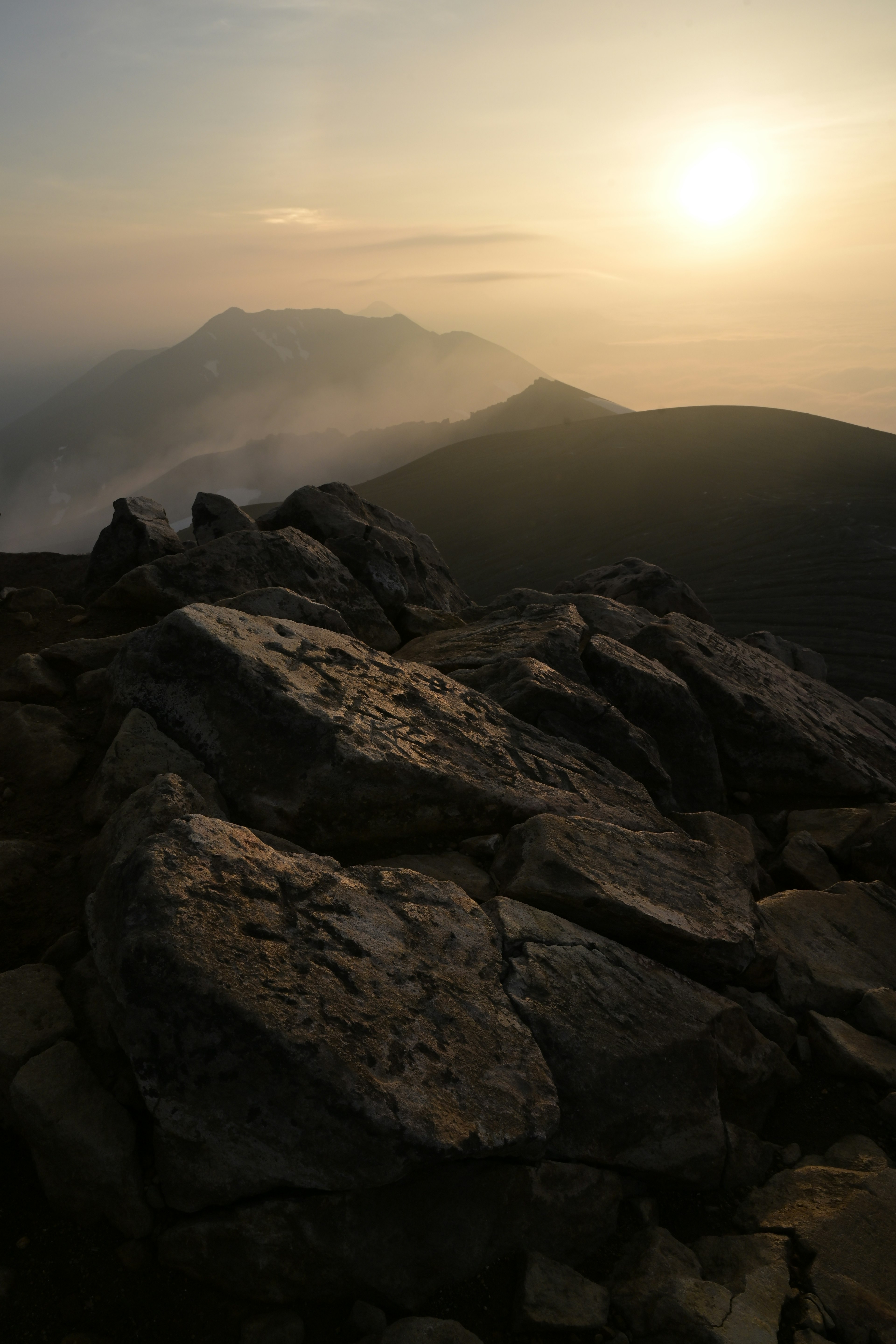 Rocce in un paesaggio illuminato dal tramonto su montagne