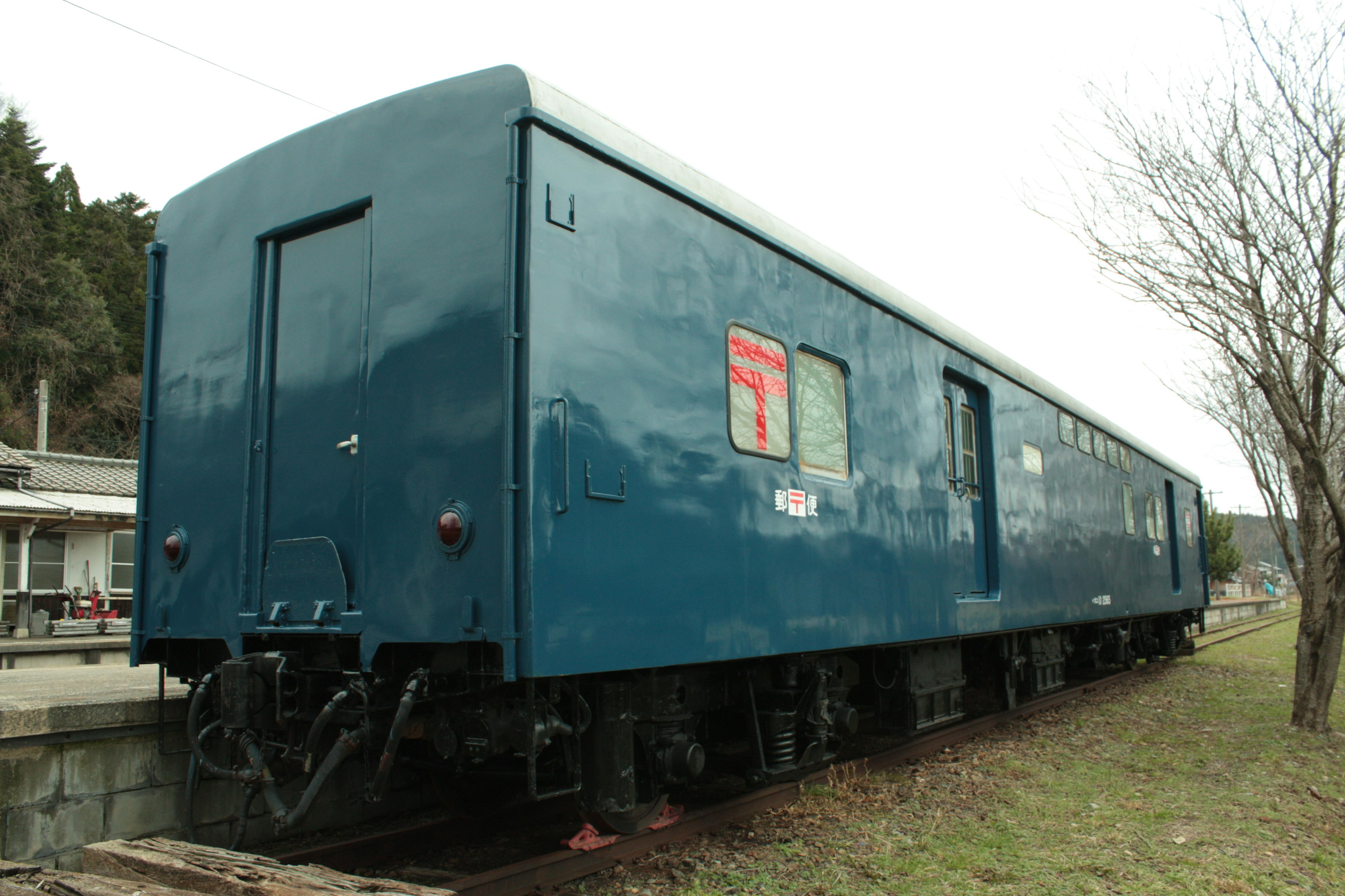 Ein blauer Zugwagen, der neben den Gleisen parkt