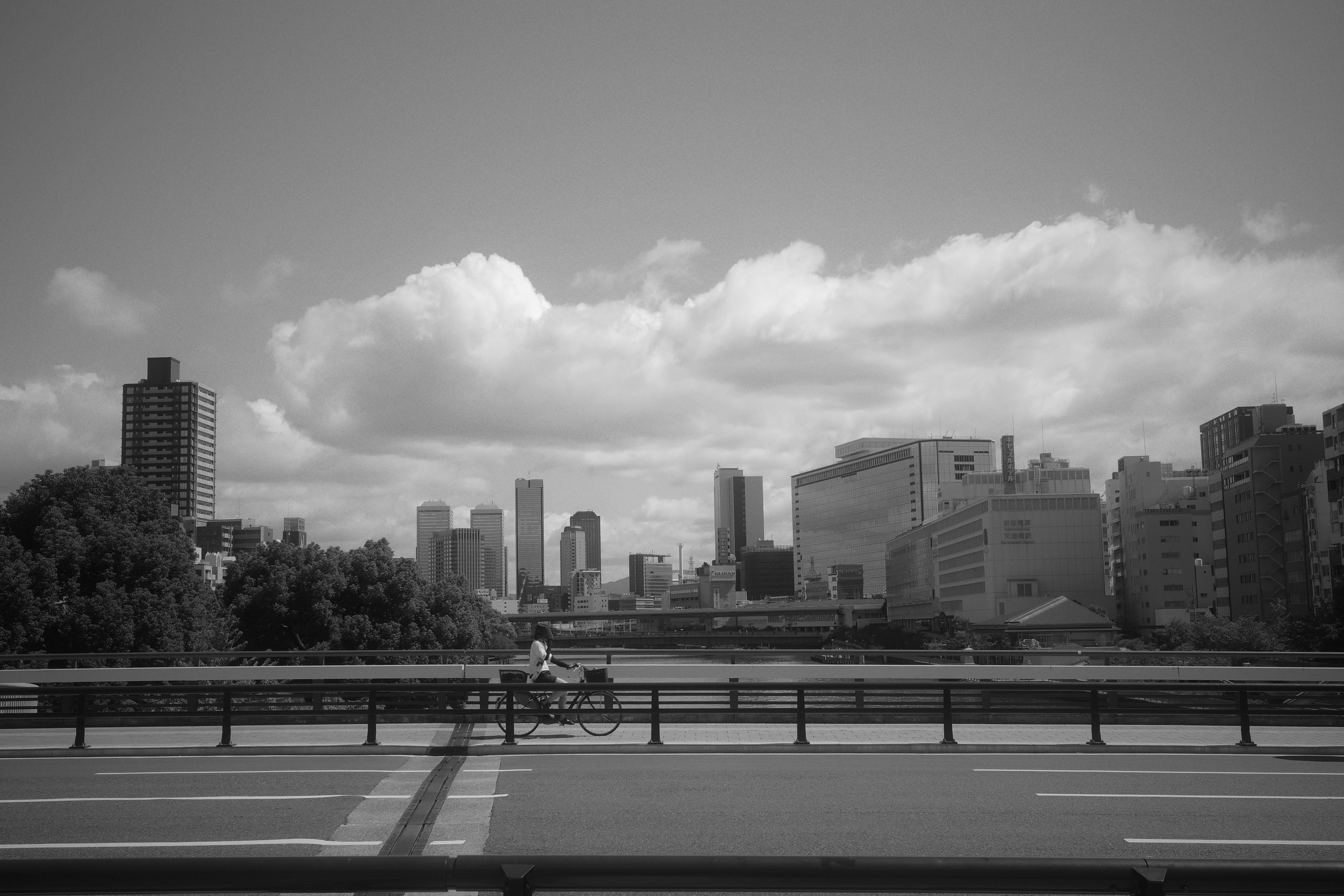 Paisaje urbano en blanco y negro con un puente y rascacielos al fondo