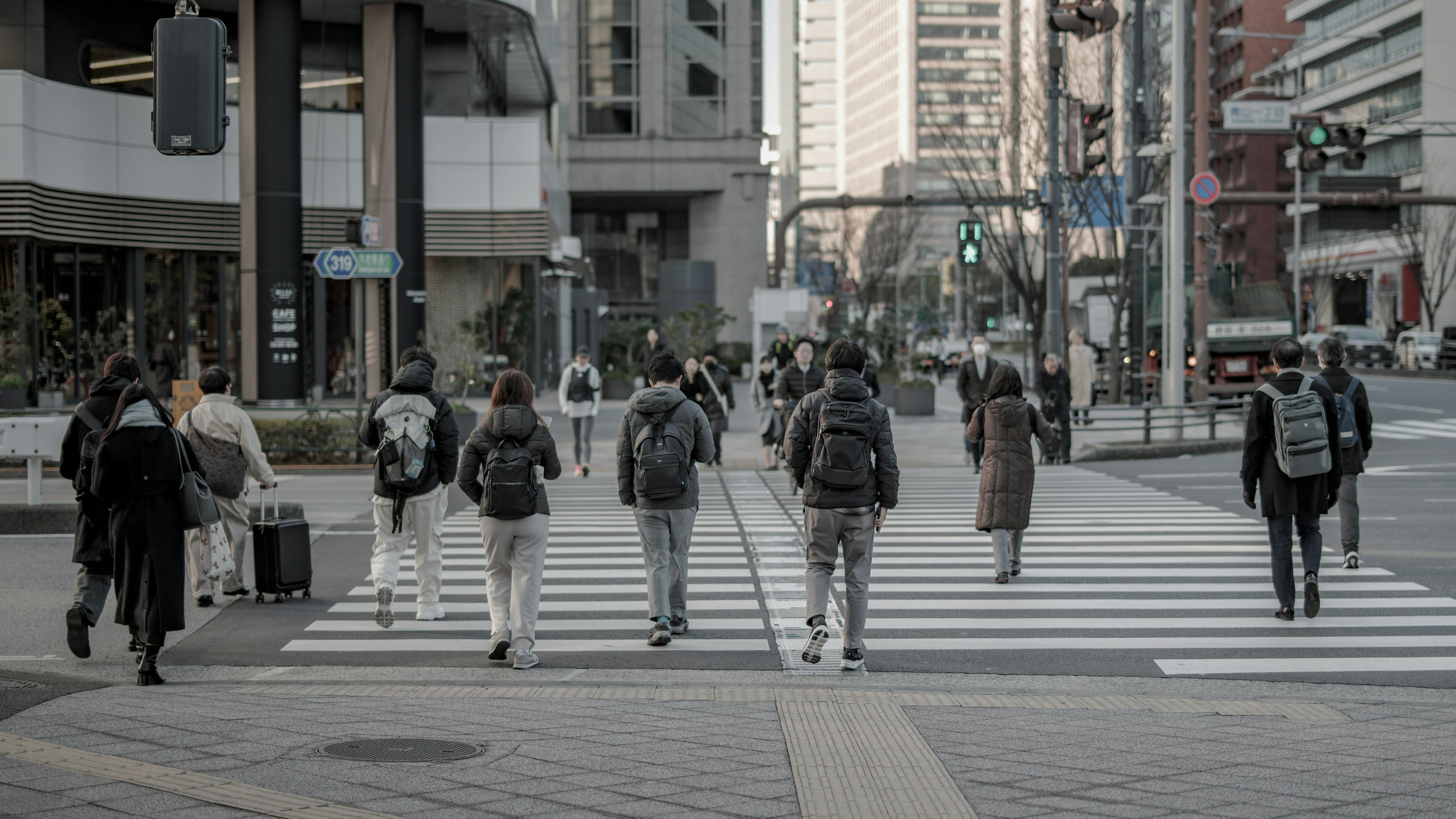 人們在城市環境中穿越人行道 背景是摩天大樓