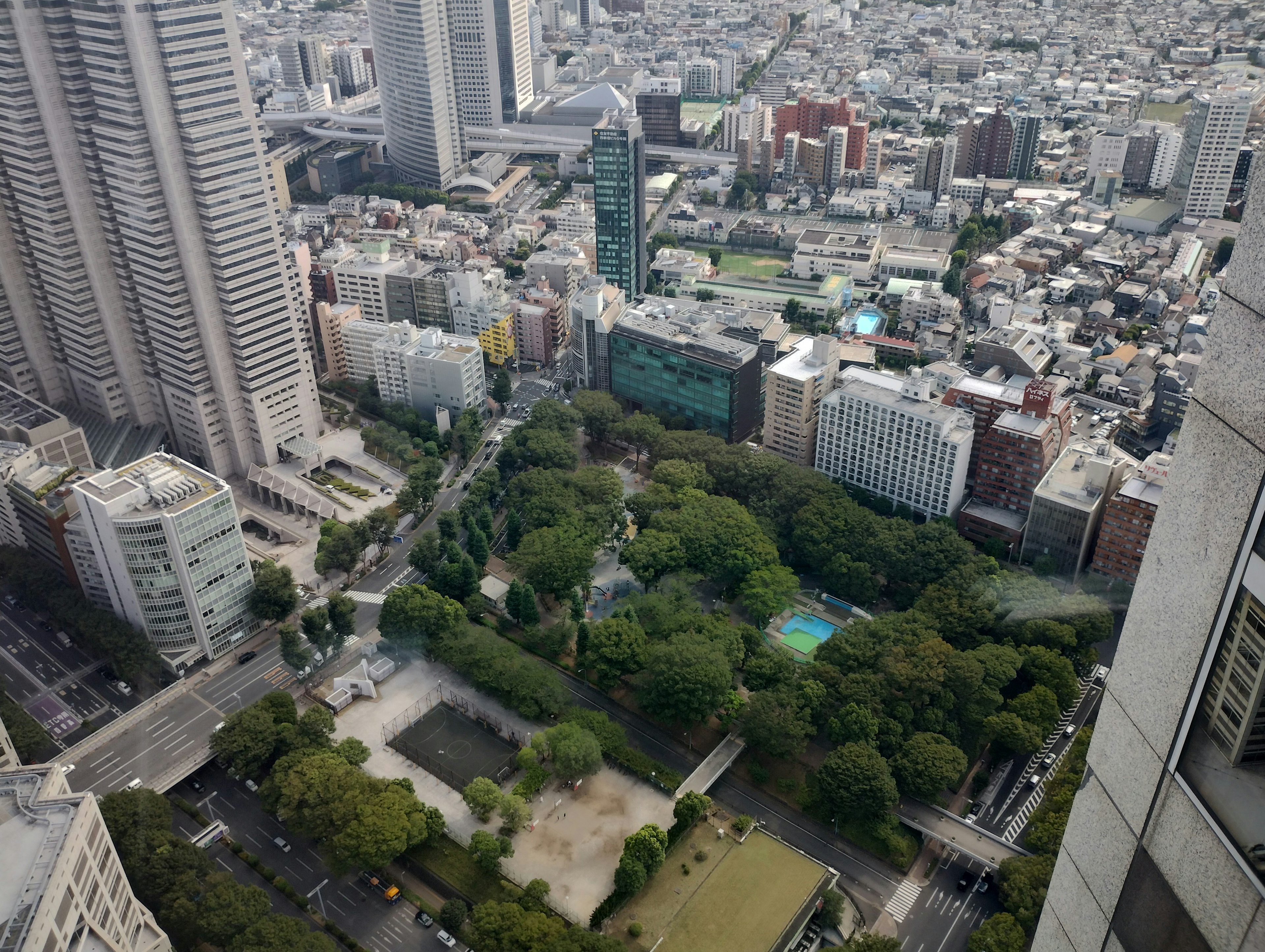 Aerial view of a city landscape with a lush green park and surrounding buildings