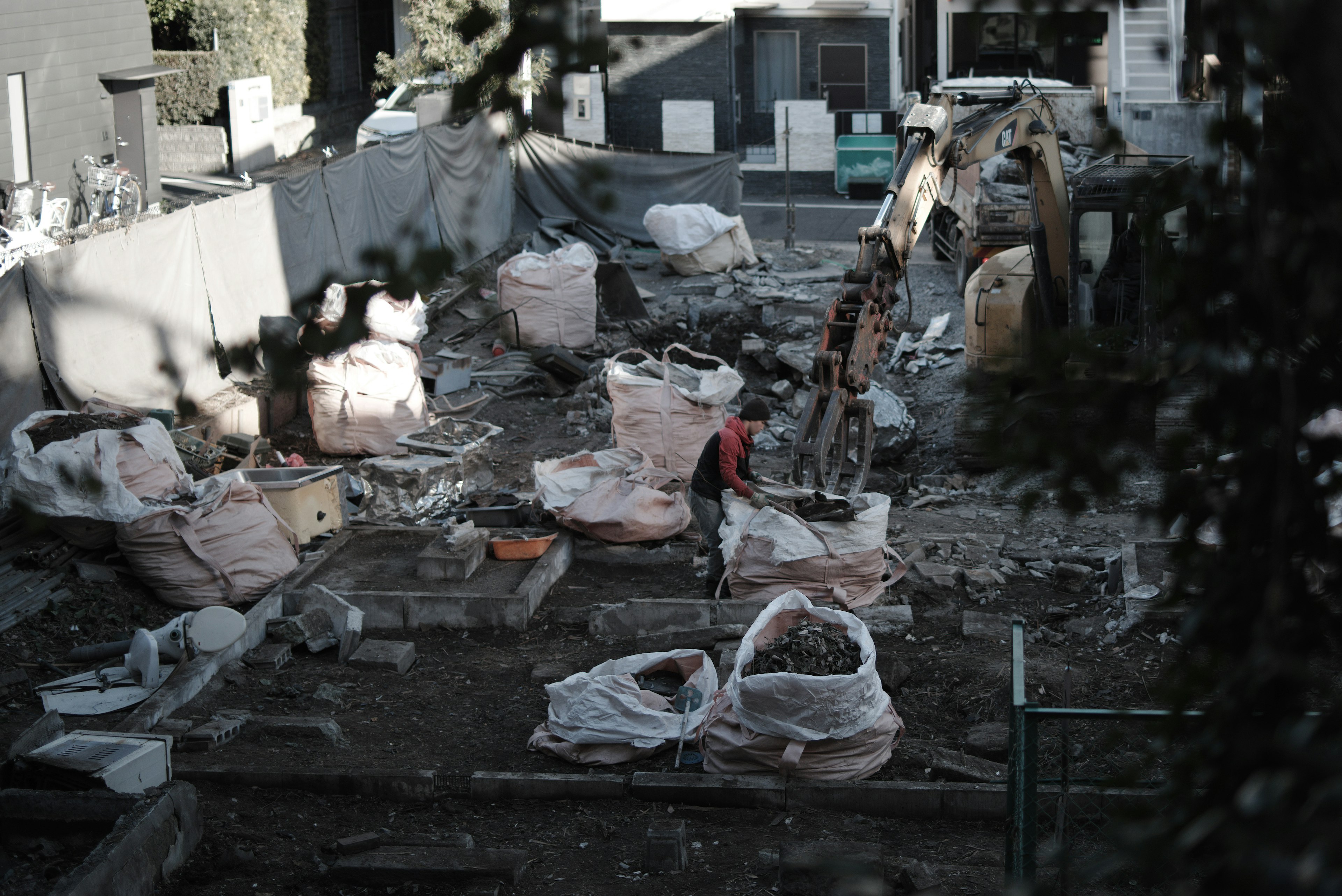 Sitio de construcción con un trabajador y maquinaria pesada visible