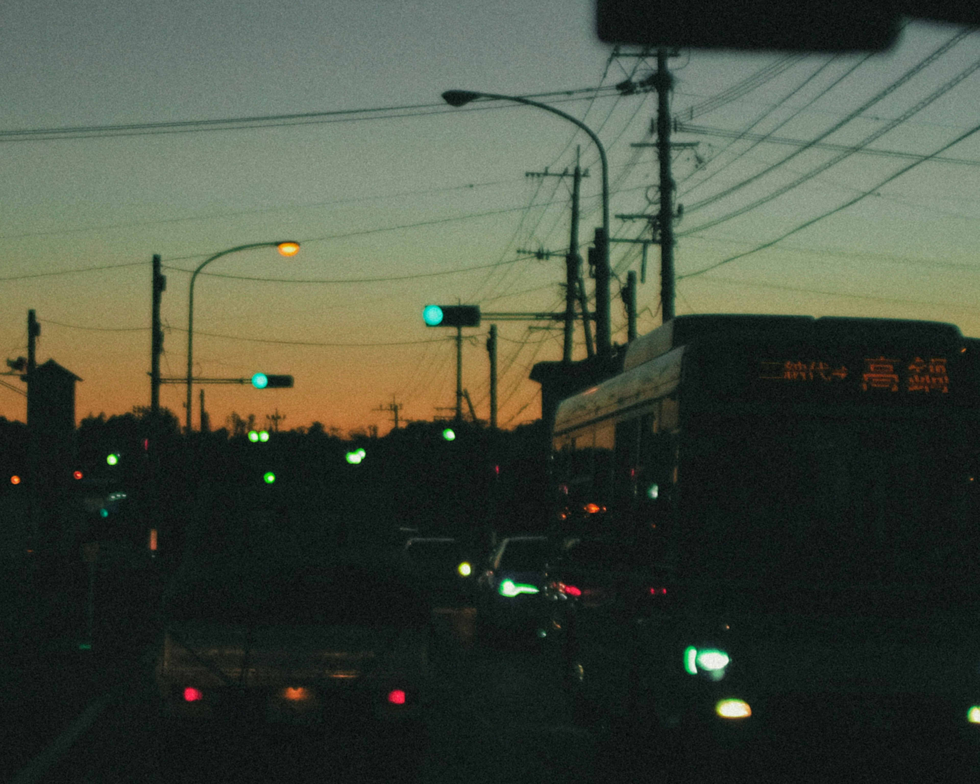 Intersección al atardecer con semáforos y un autobús