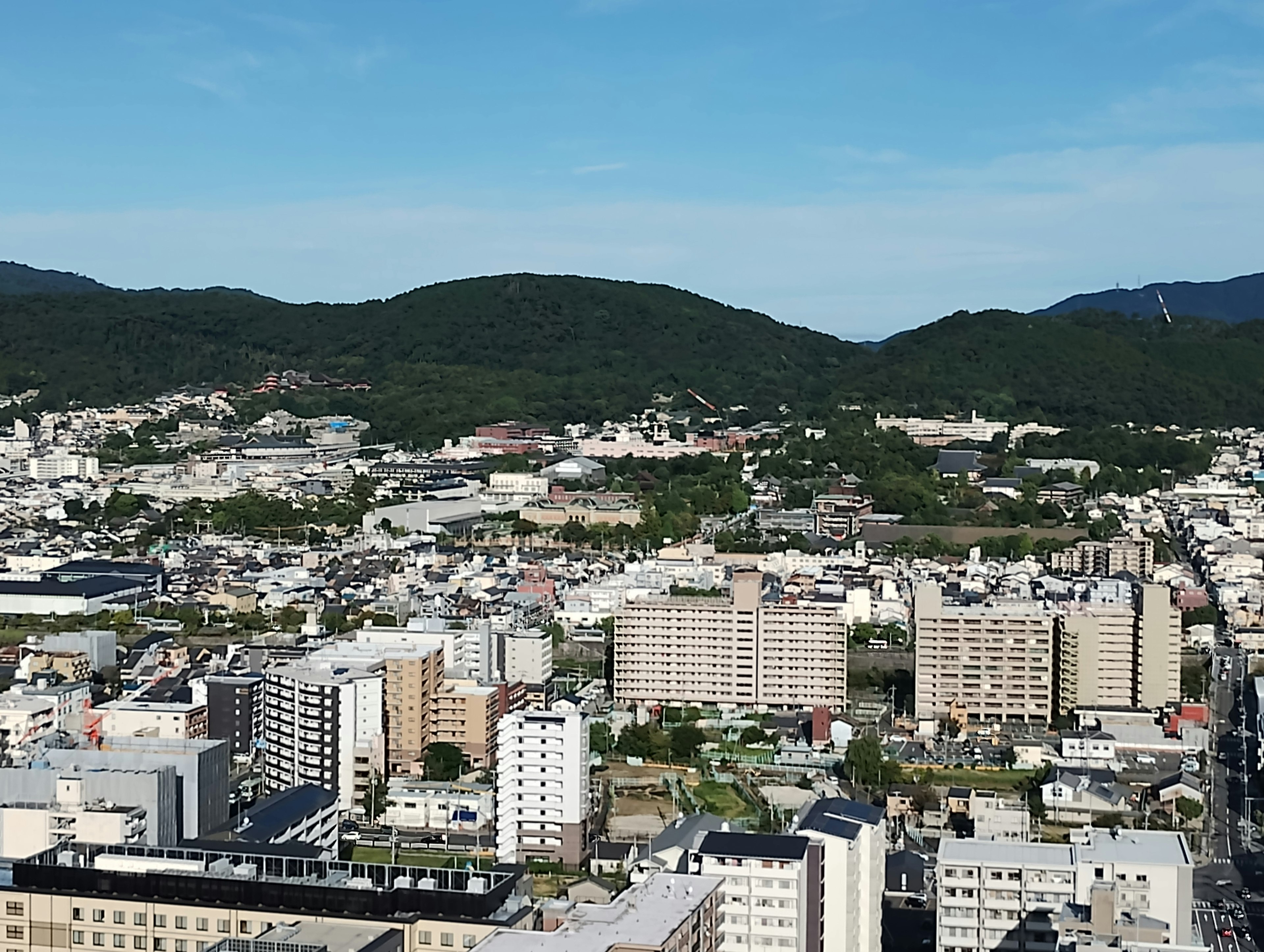 Cityscape featuring buildings and lush green hills