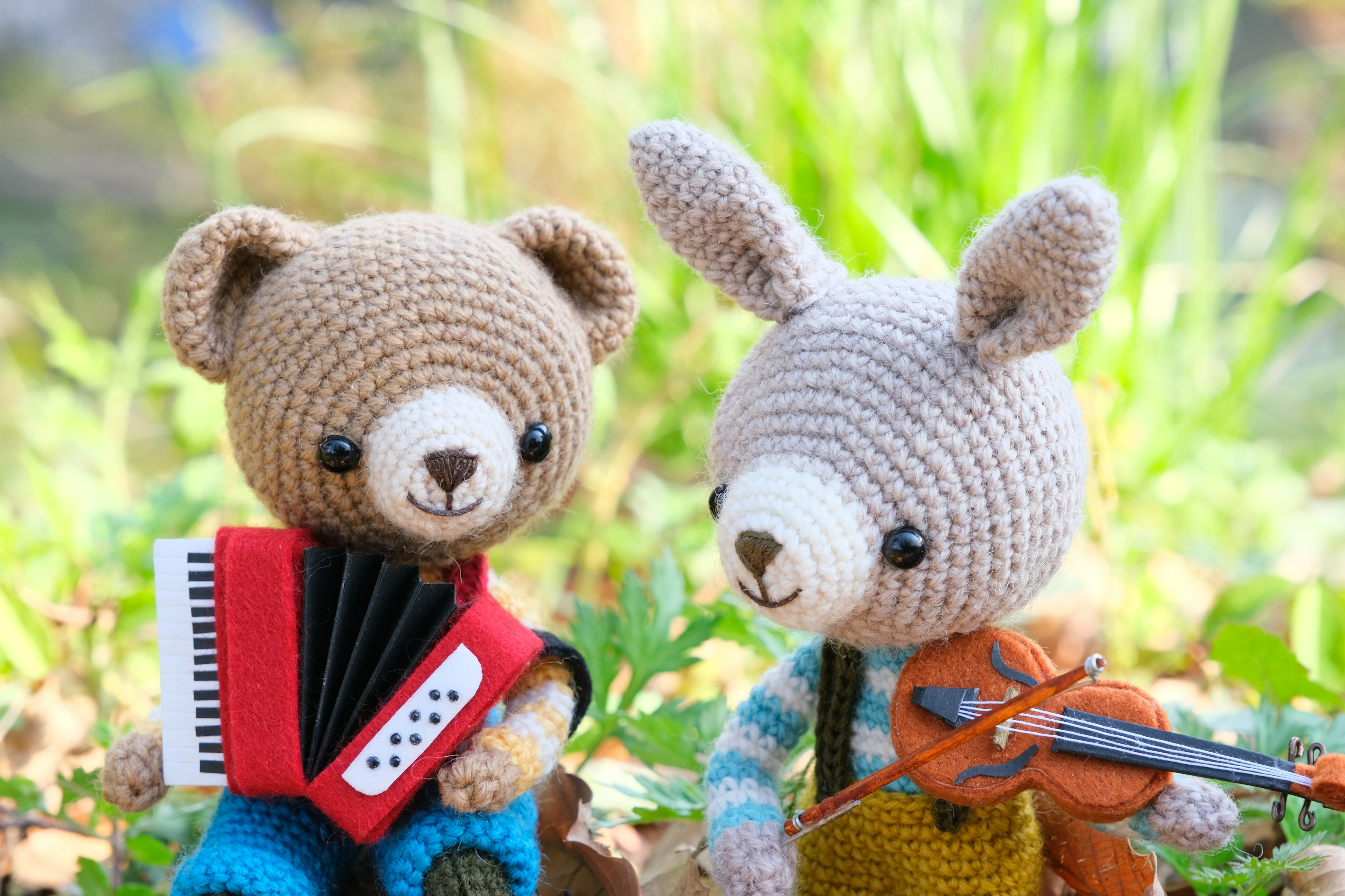 Cute crocheted bear and rabbit holding musical instruments