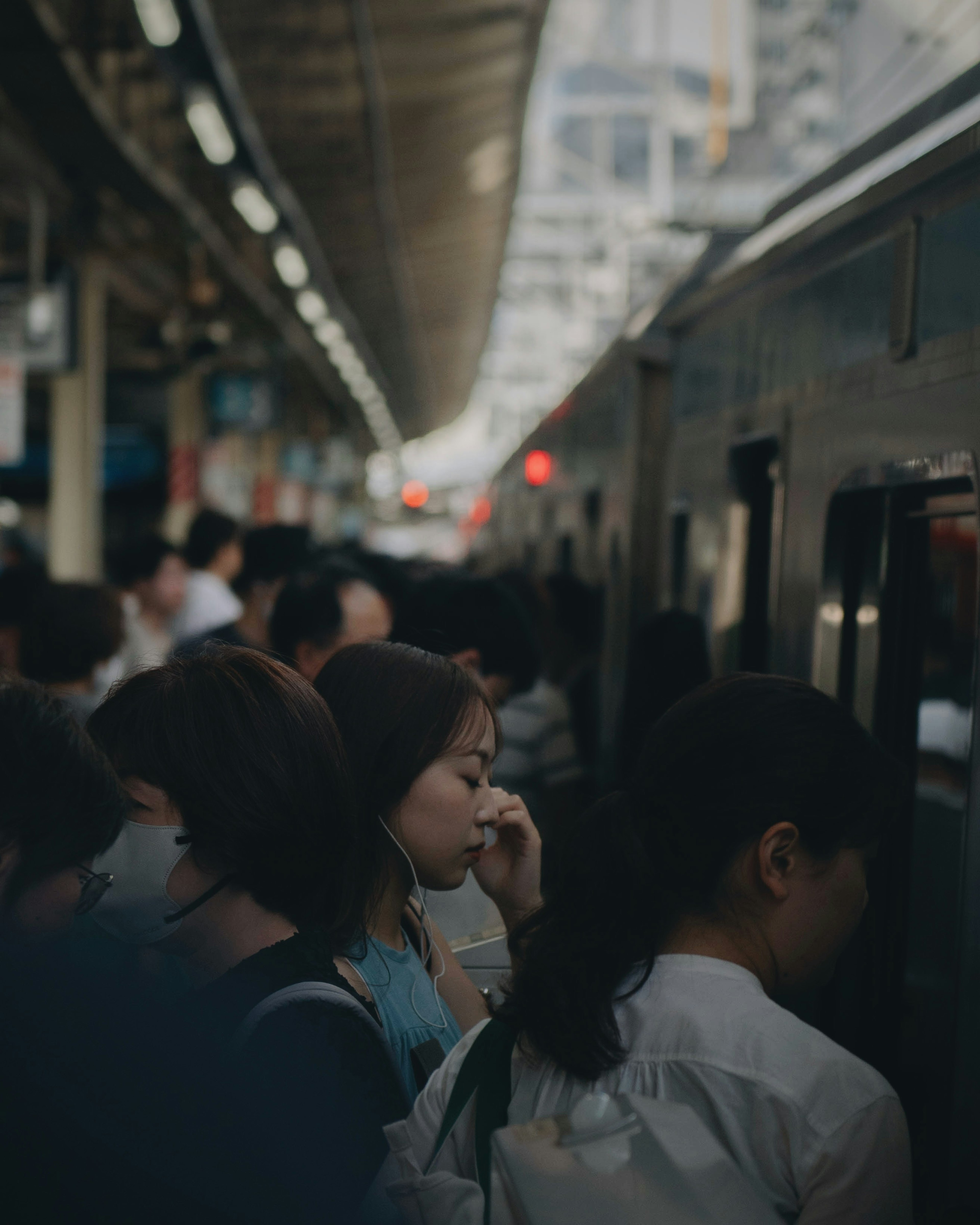 混雑した駅で電車を待つ人々の群れ