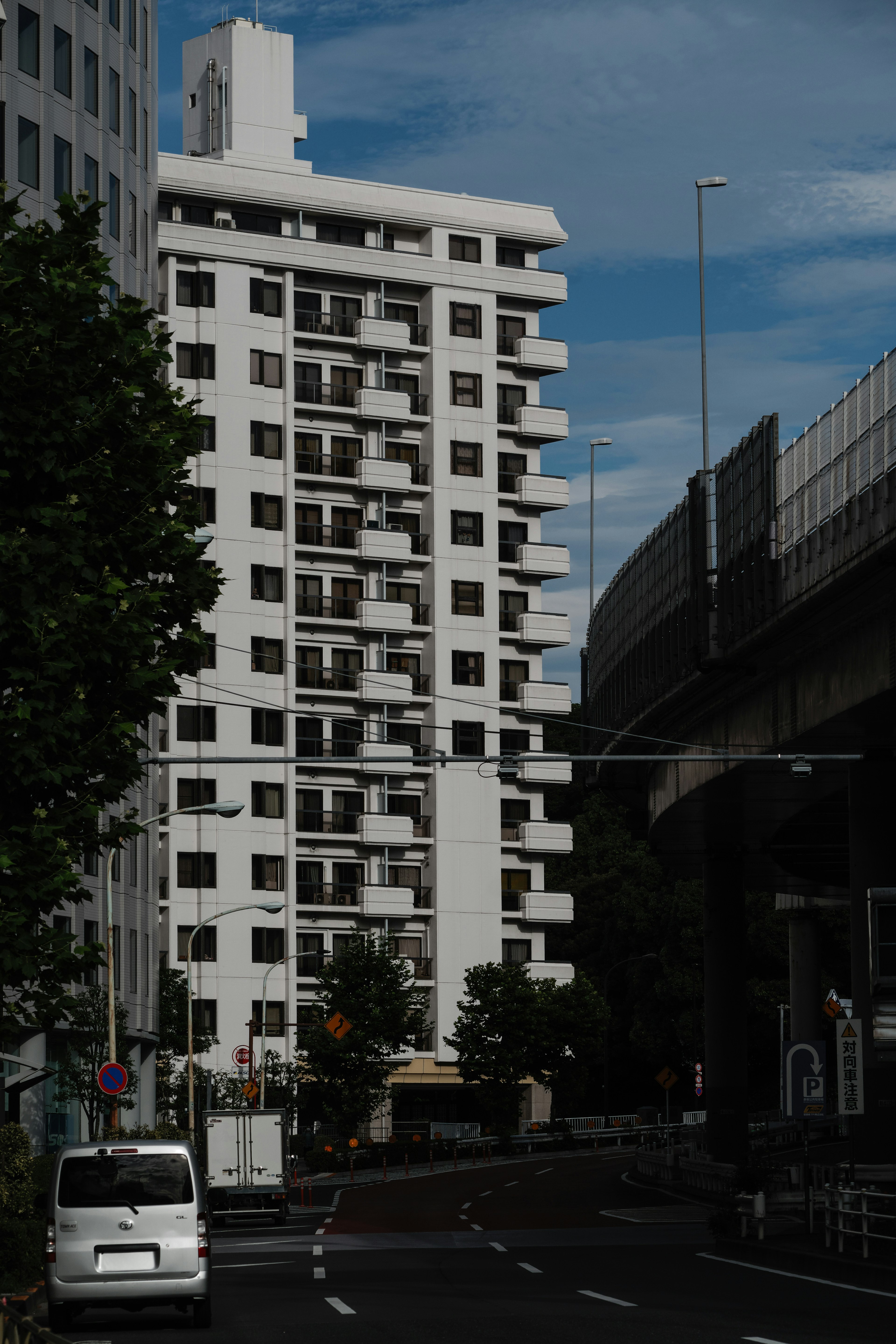 Scène urbaine avec un immeuble d'appartements blanc et des arbres verts